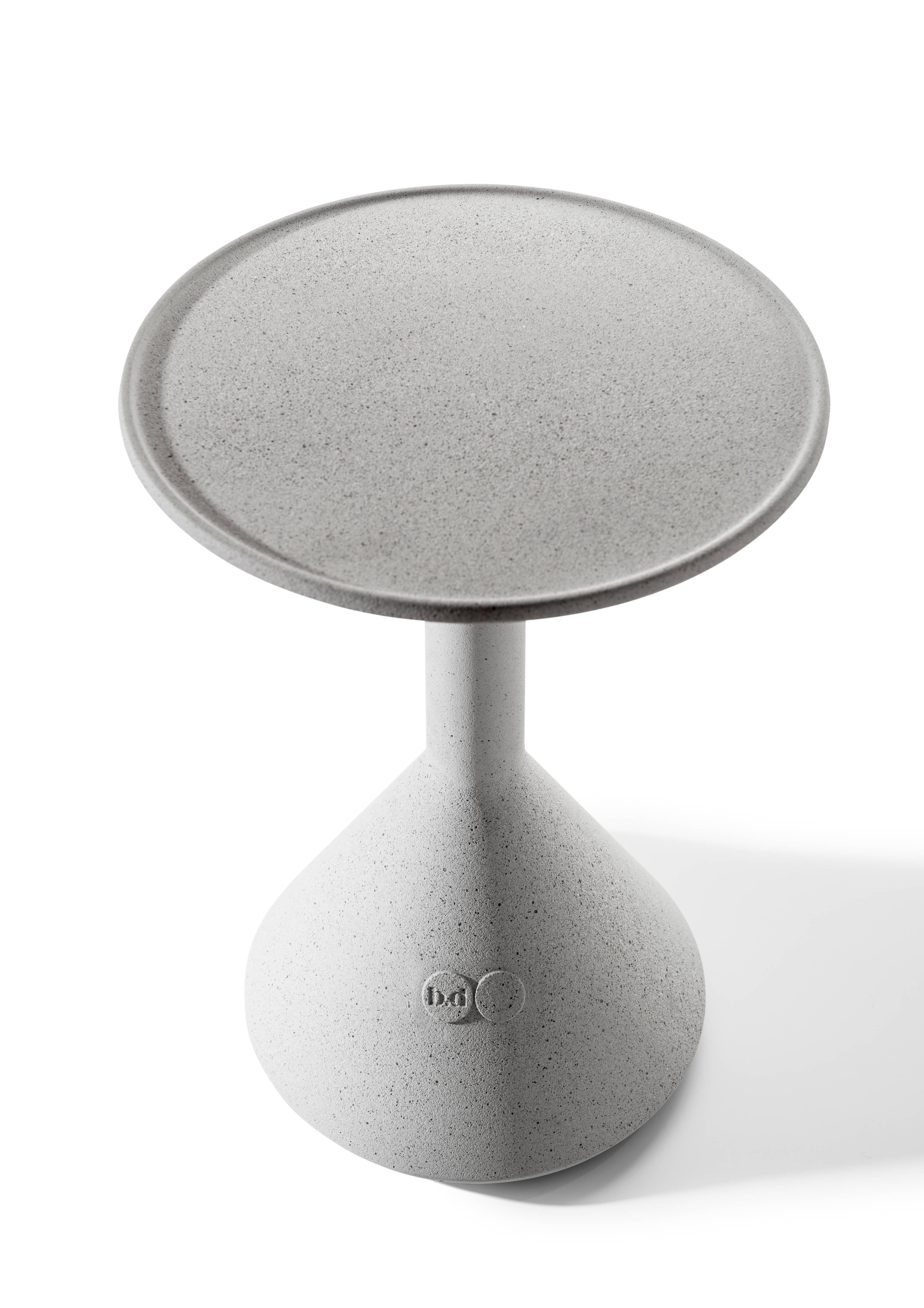 Table d'appoint en ciment massif architectonique de couleur grise.