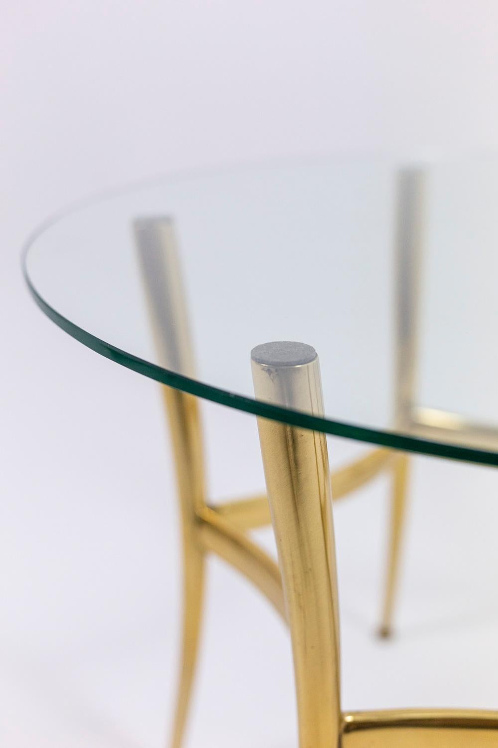Side table. Glass top standing on a round golden brass base.

Work realized in the 1970s.
  