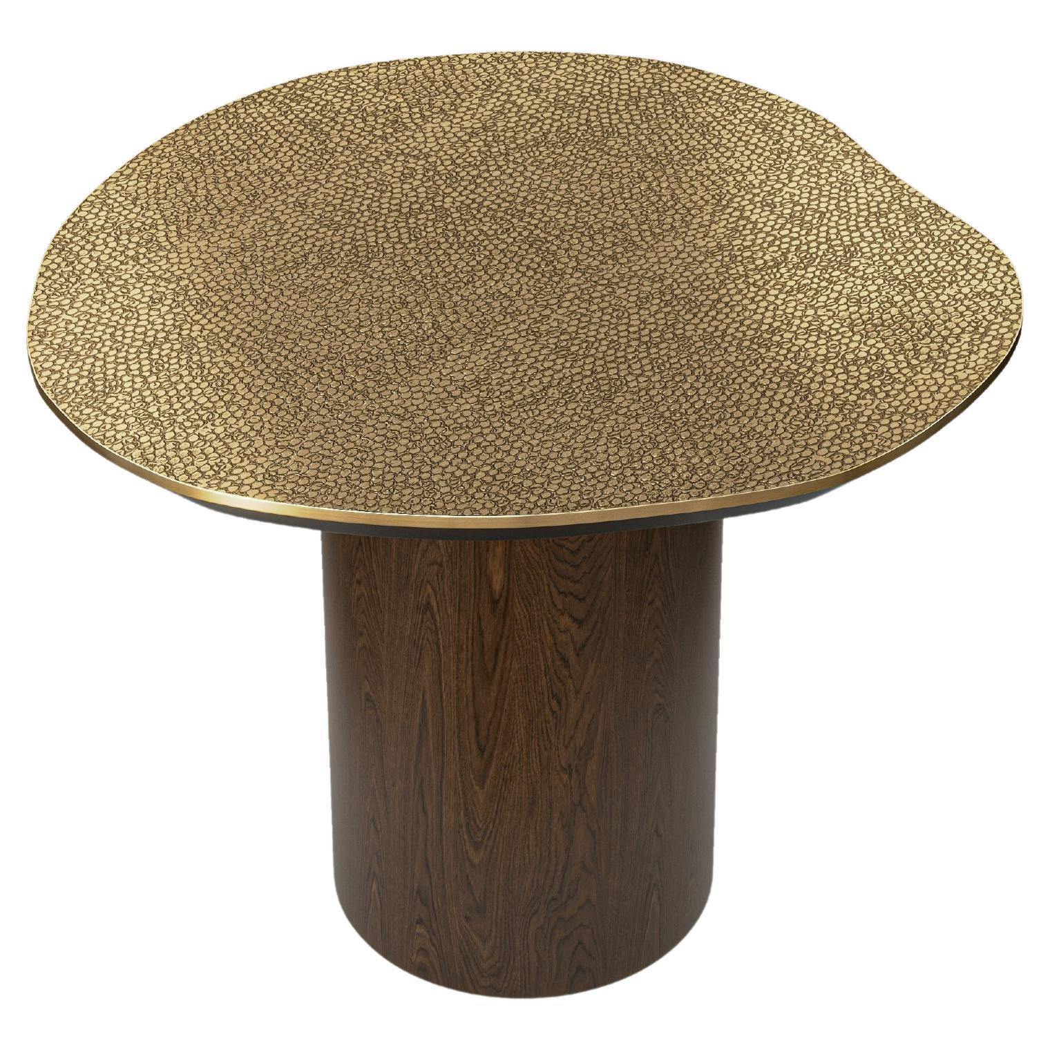 This side table from the Earth Prints series features a balanced silhouette enhanced by a refined combination of materials. Its round brass top, measuring 72 cm in diameter, is hand-hammered to create a stingray-inspired texture, giving the surface