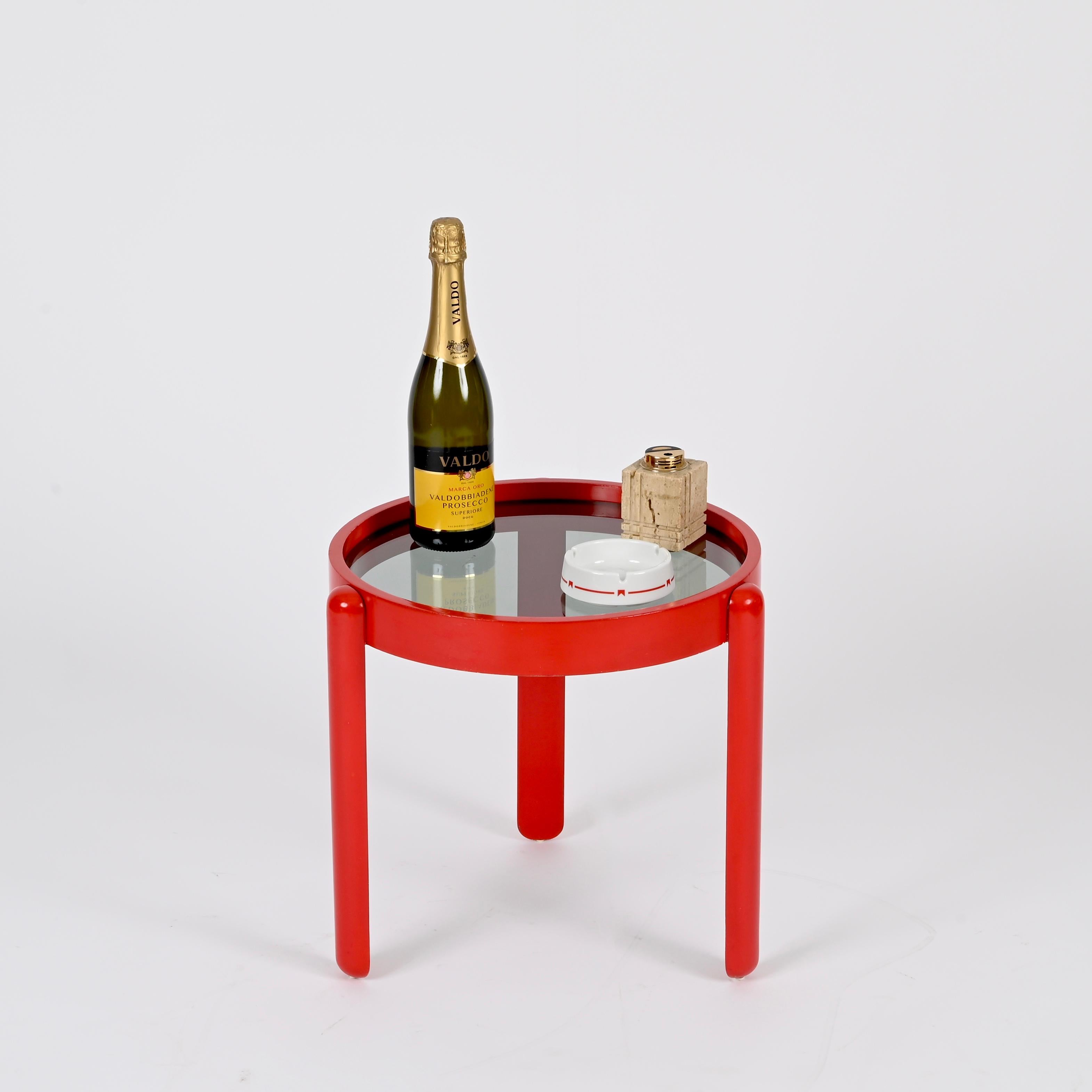 Maravillosa mesa auxiliar de mediados de siglo en roble lacado rojo y cristal ahumado. Esta elegante mesita se atribuye a Gianfranco Frattini y se fabricó en Italia en la década de 1960.

Totalmente original y en un estado increíble. La estructura