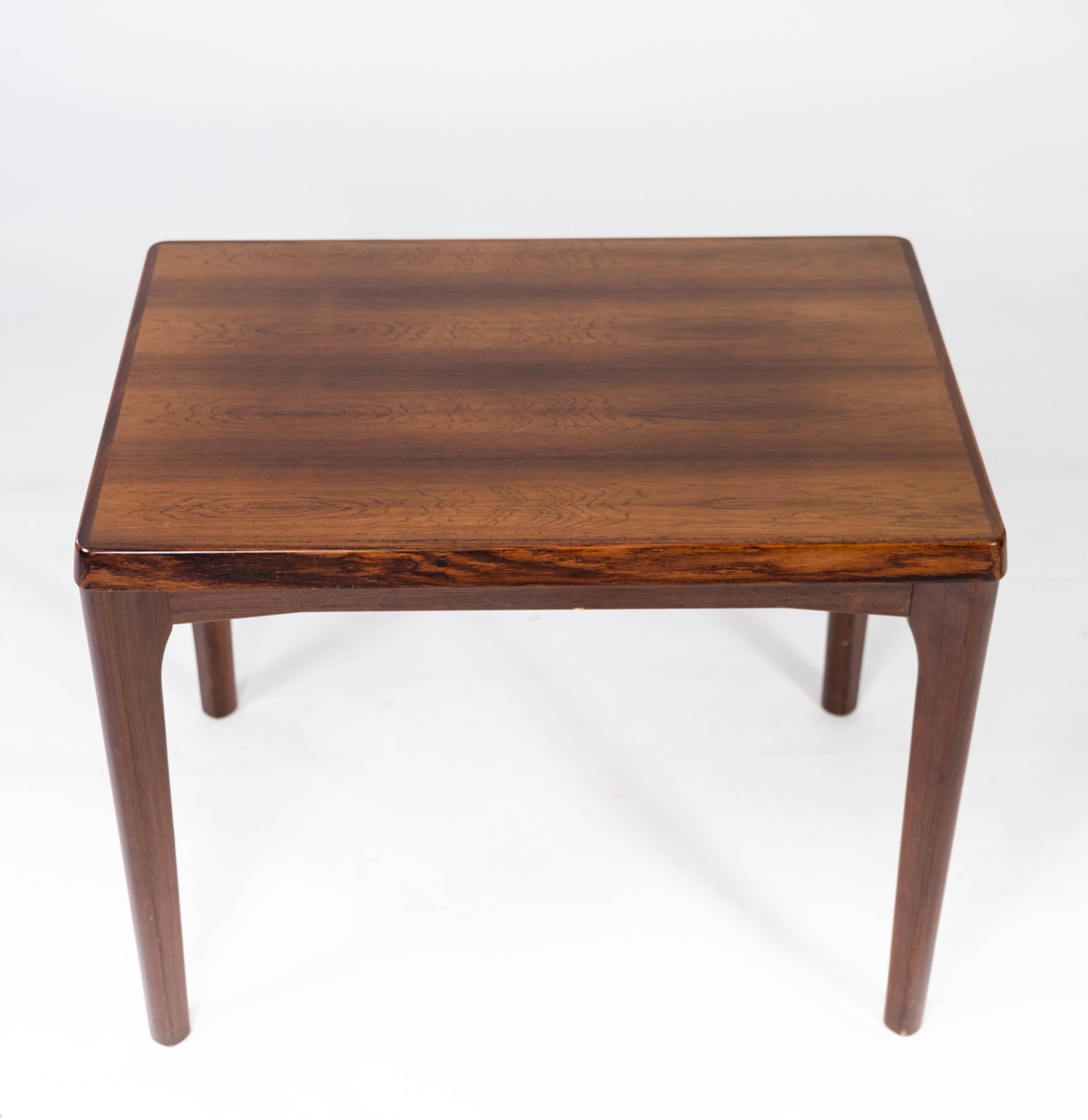 This rosewood side table, a creation of Henning Kjærnulf in the 1960s, epitomizes the elegance of Danish mid-century design. Crafted with precision and finesse, it seamlessly blends form and function, making it a timeless addition to any interior