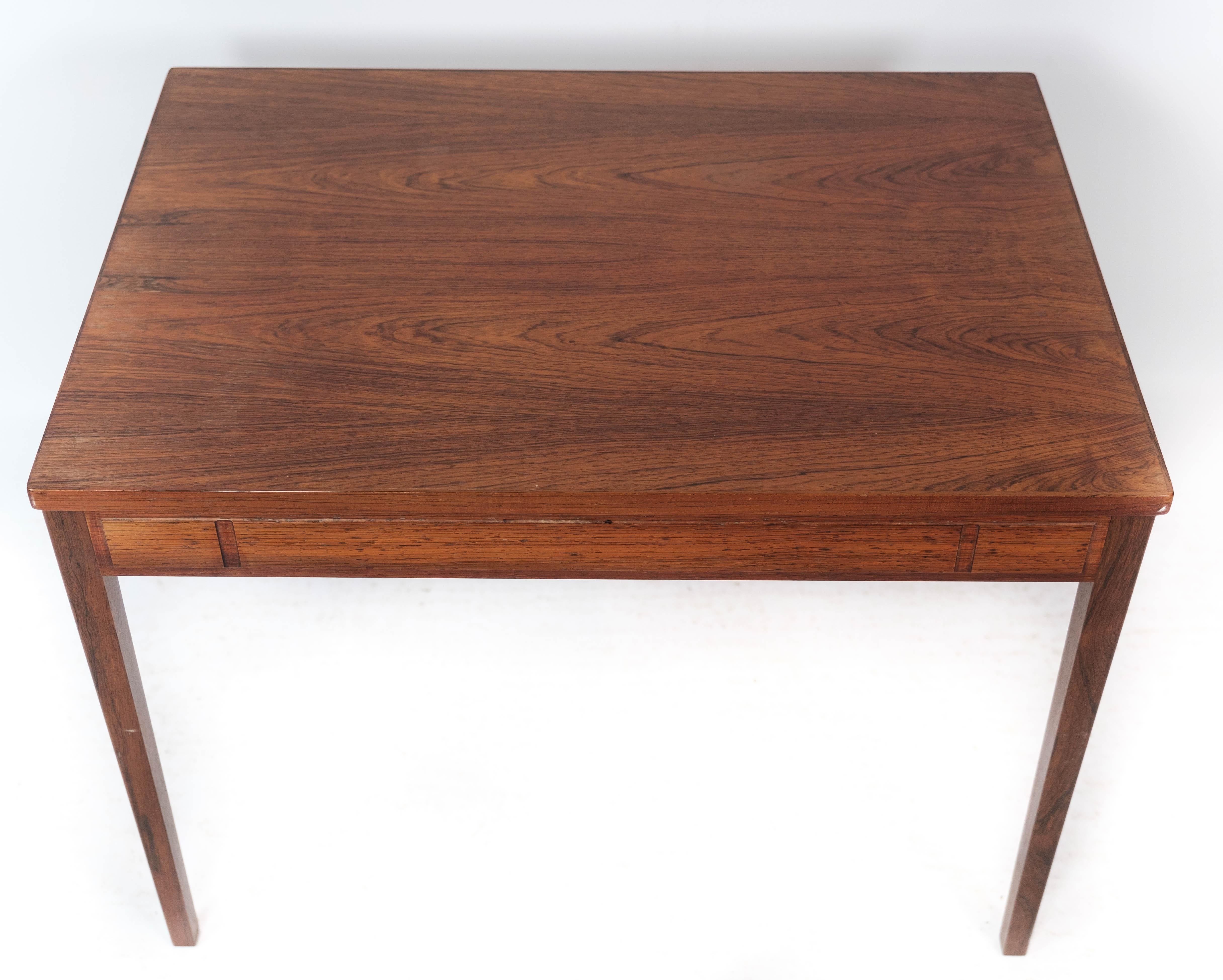 
Der aus Palisanderholz gefertigte Beistelltisch mit dänischem Design aus den 1960er Jahren ist ein eindrucksvolles Beispiel für die moderne Eleganz der Mitte des Jahrhunderts.

Rosenholz, das für seine satten Farbtöne und ausgeprägten Maserungen
