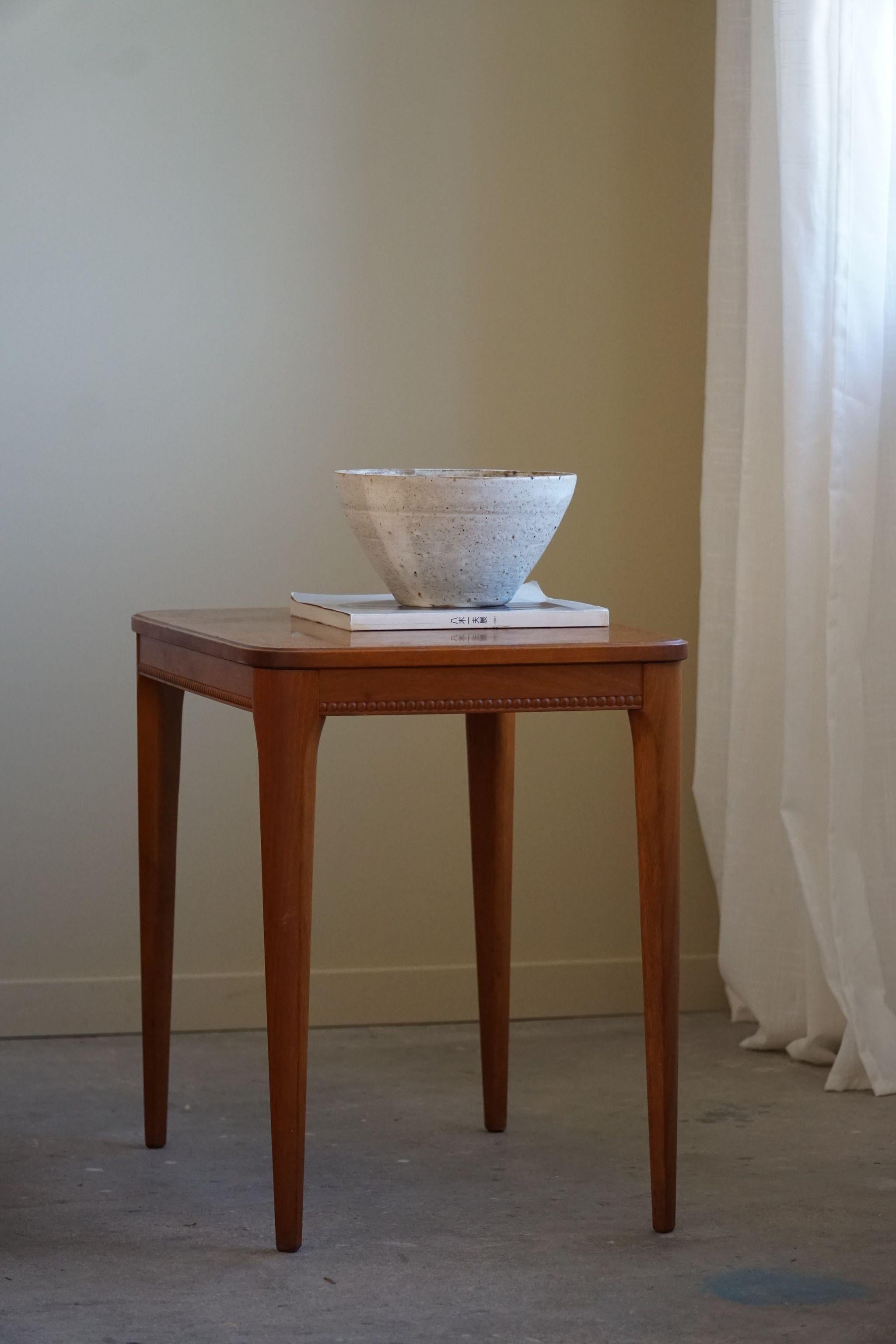 Side table in teak with decorative globes around the edge. Made by a skilled Danish cabinetmaker in the 1950s. This timeless classic table will complement many interior styles. A modern, bohemian, classic, Scandinavian or an Art Deco home