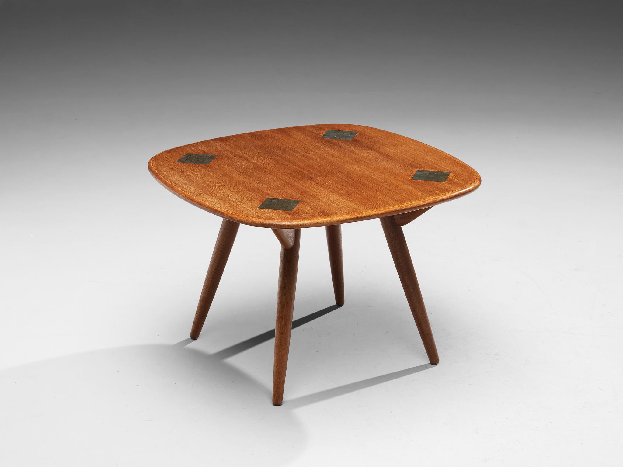 Side table, teak, ceramics, Europe, 1950s

Squared side table with ceramic inlays. This mid-century coffee or side table features a distinctly shaped top. The square has rounded corners and four ceramic inlays. Here, small mosaic fragments form