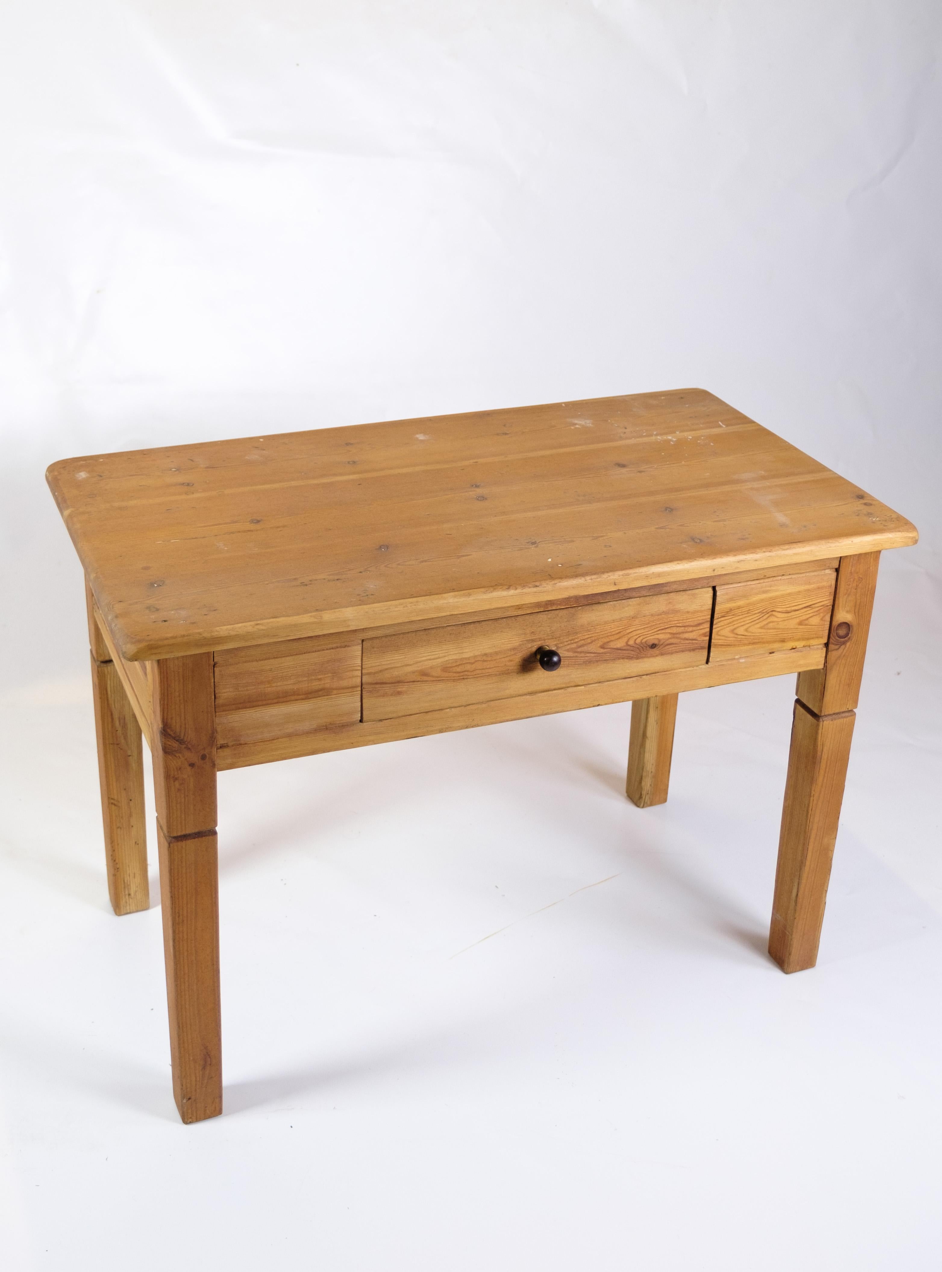Cette table d'appoint en pin avec un tiroir, datant des années 1920, est un charmant exemple de mobilier du début du XXe siècle. Sa construction simple mais robuste et son aspect vintage ajoutent du caractère et un attrait nostalgique à n'importe