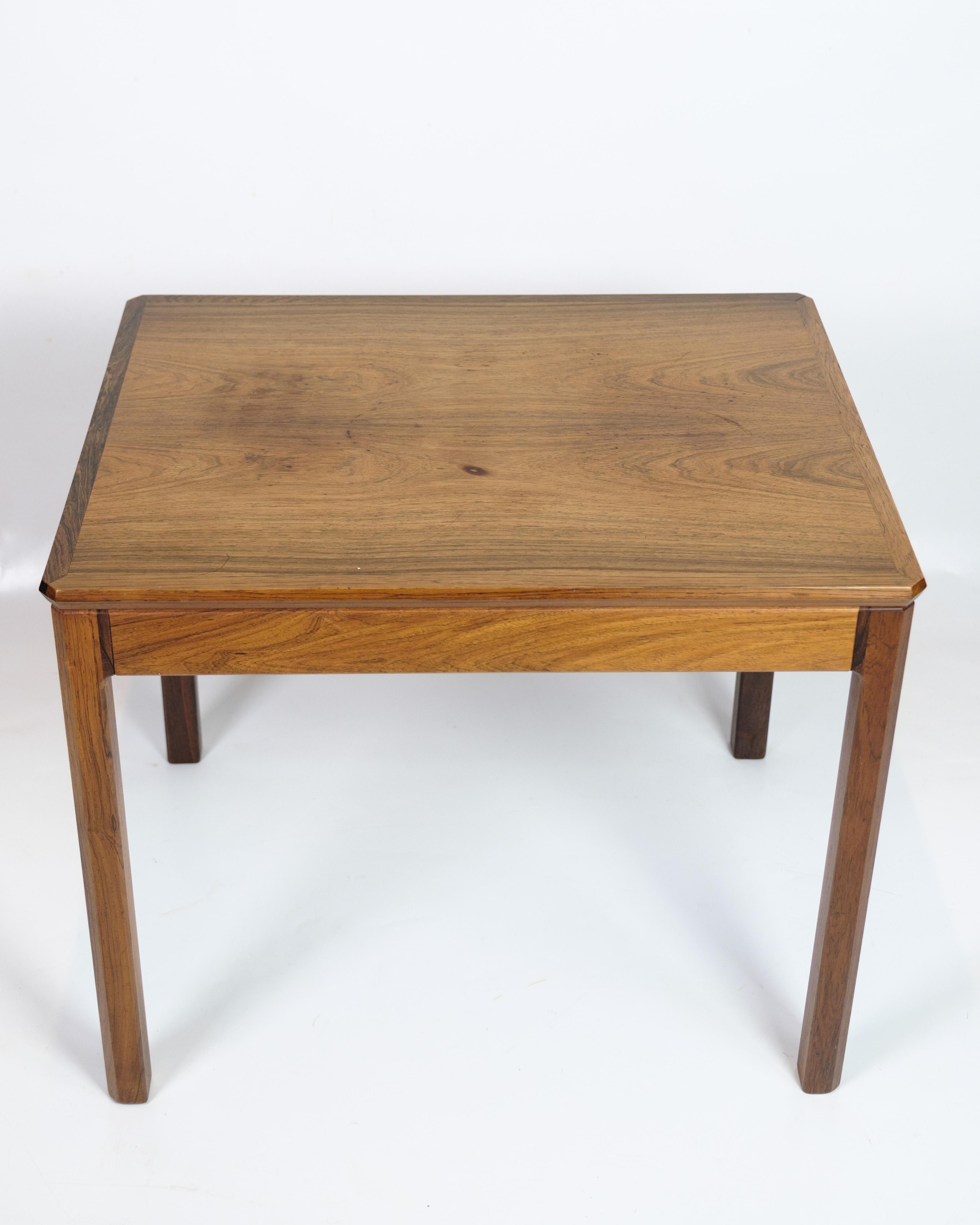 Table d'appoint en palissandre des années 1960, fabriquée selon le design danois. La table est fabriquée en magnifique bois de rose aux veinures claires et élégantes, ce qui lui confère une expression exclusive et naturelle. Grâce à son design