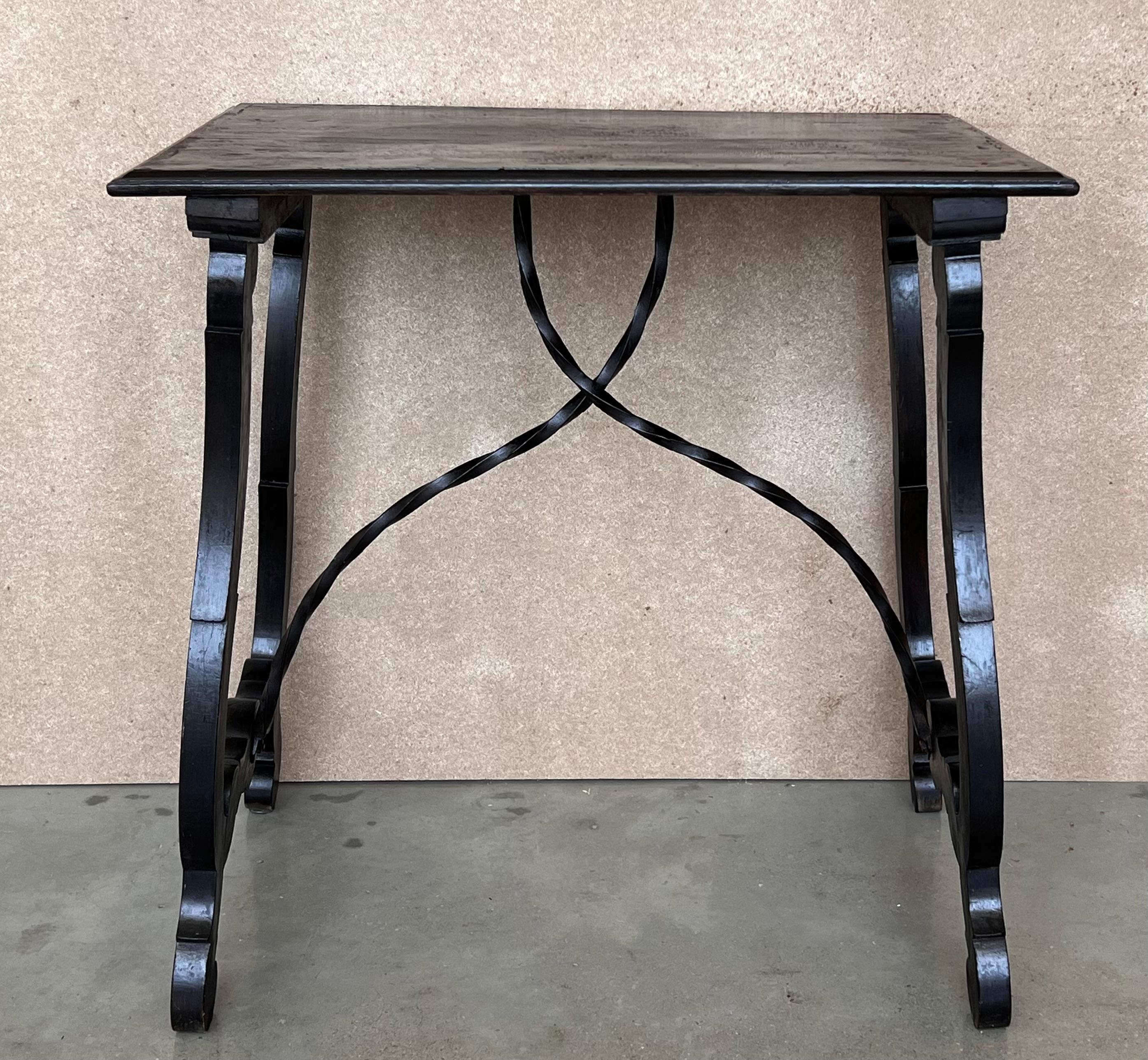 Side table of walnut with carved lyre legs with carved edges in top. Beautiful iron stretcher, Spanish, 19th century.