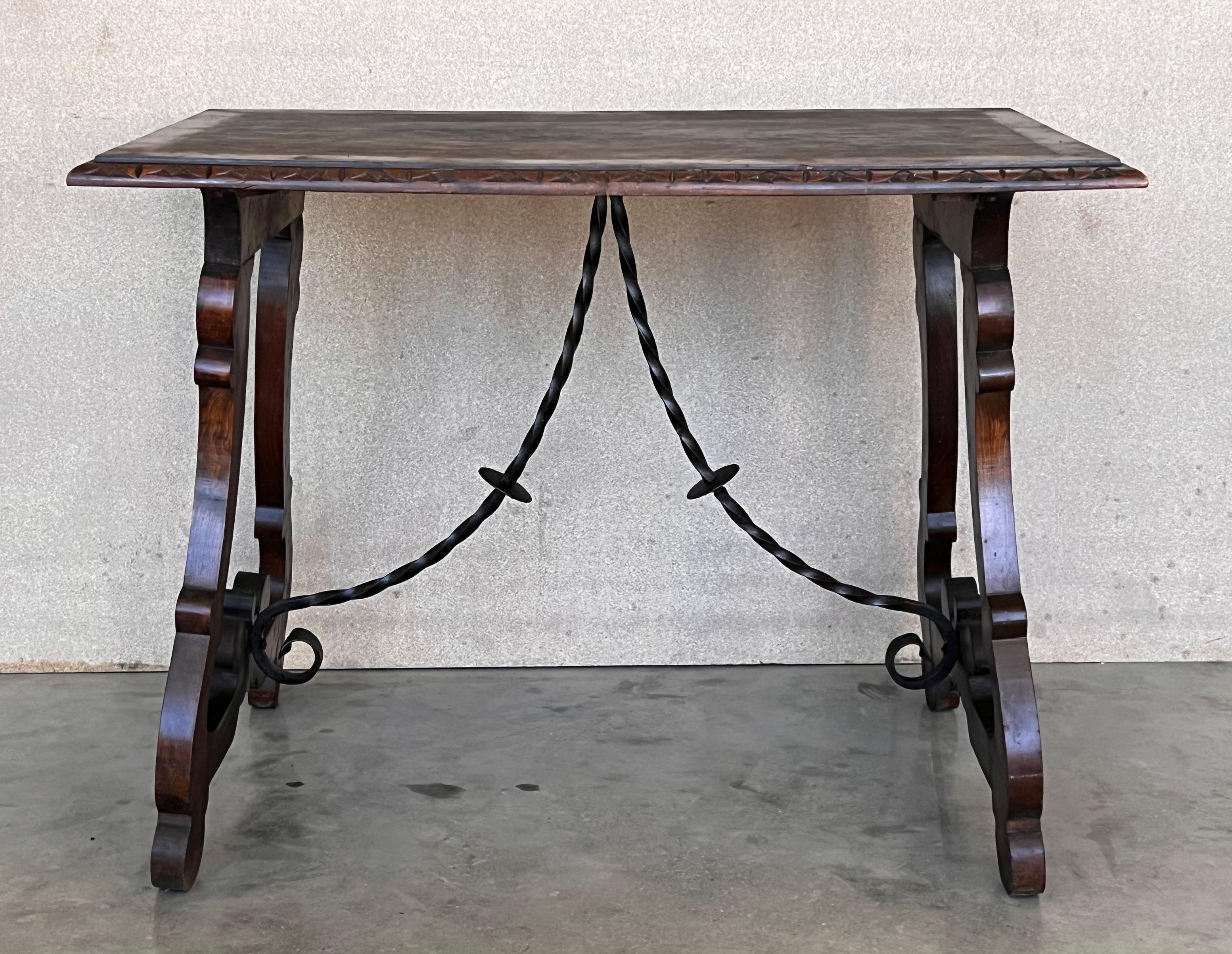 Side table of walnut with carved lyre legs with carved edges in top. Beautiful iron stretcher, Spanish, 19th century.