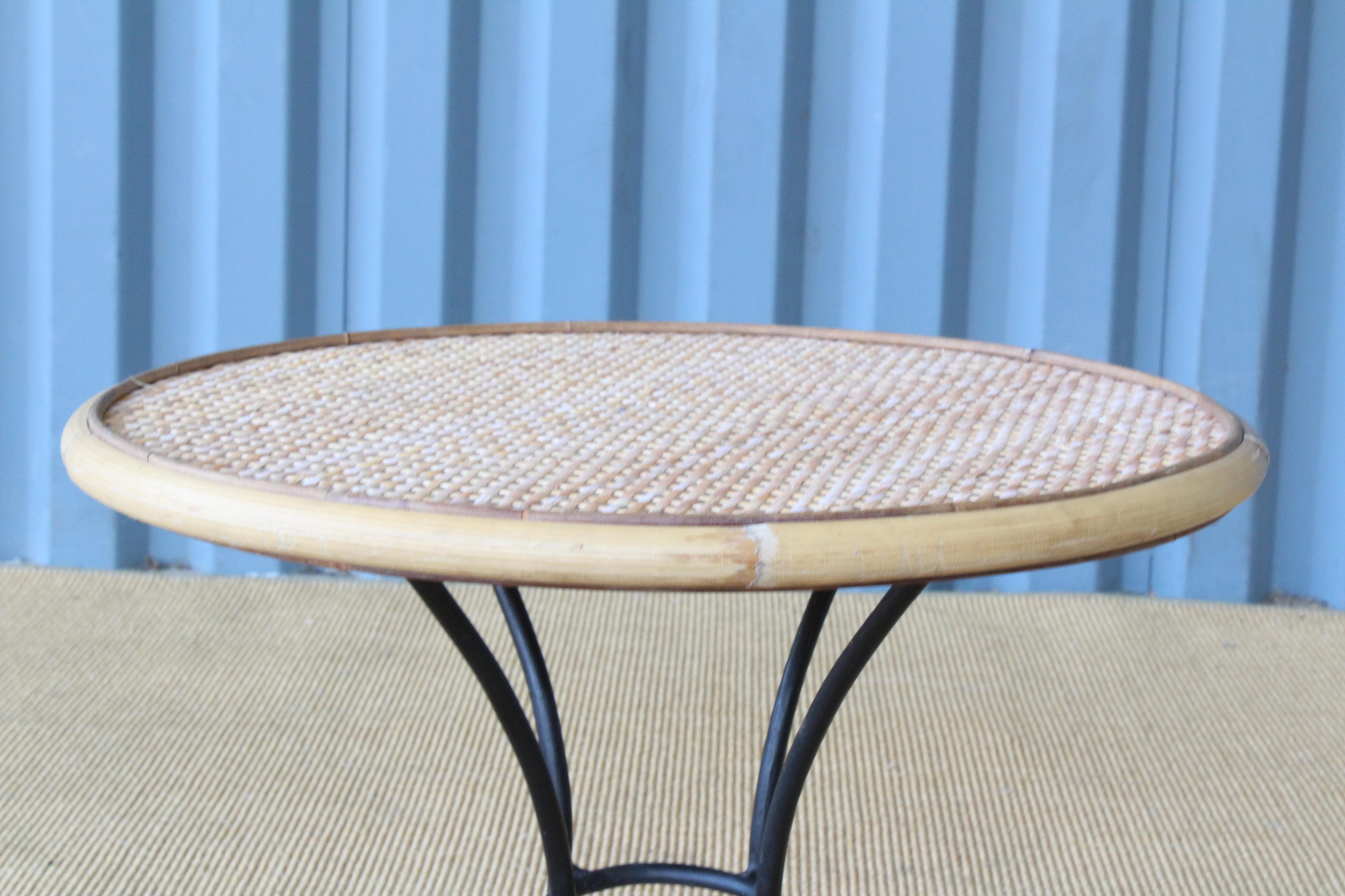 Rattan and bamboo side table on an iron base. Tabletop is new and copied from original. Iron base is original with signs of wear.