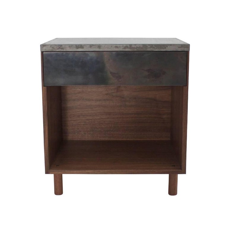 This side table features one walnut drawer, a cast-concrete top and hand-turned walnut legs. The fascia is cold-rolled steel laminated to a walnut veneer core. The steel, a characteristically cold material, into one that projects warmth and