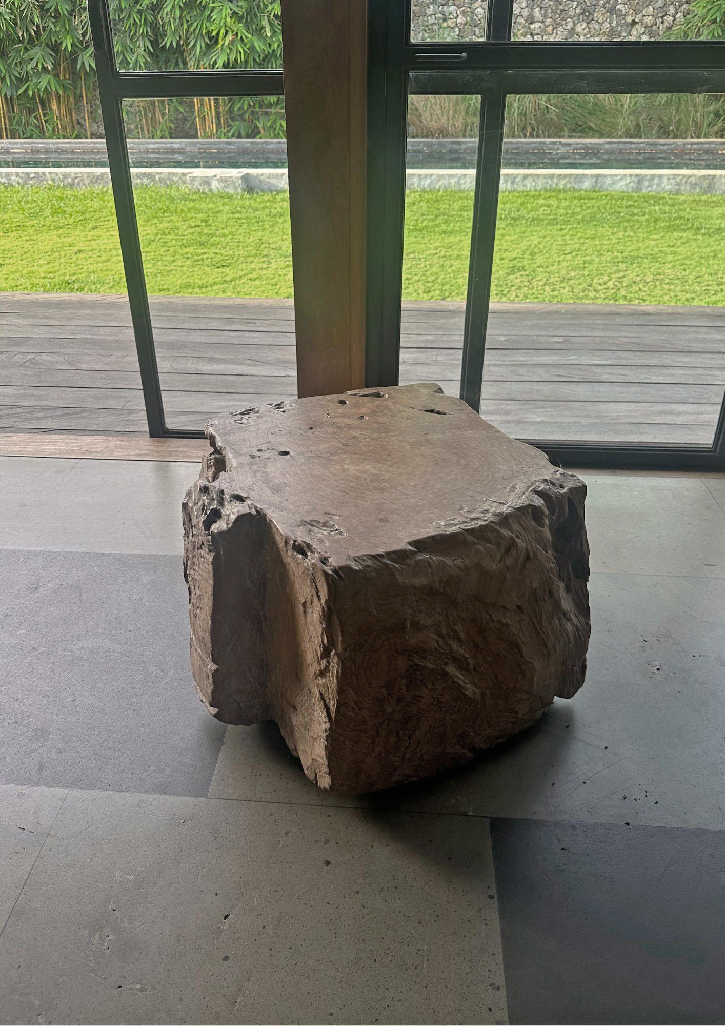Une table d'appoint merveilleusement organique, sculptée dans un seul bloc de ronce de teck. Son pigment neutre et sa texture boisée subtile s'intègrent parfaitement à tous les espaces. Le mélange des teintes et des textures de bois ajoute à son