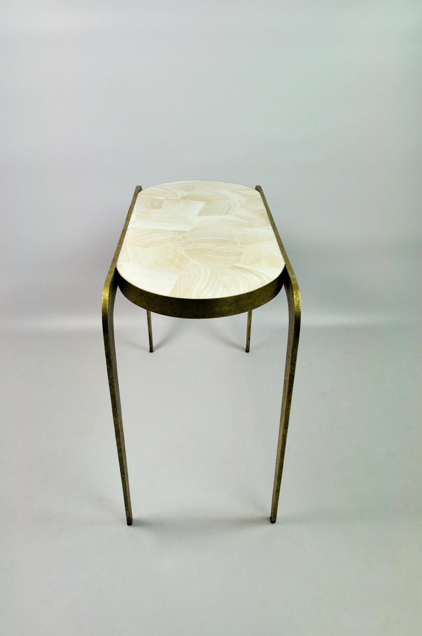 The Visio side table by Ginger Brown is made of brass with a polished giant clam fossil marquetry top.
The brass is hammered by hand and gives an unique texture while contrasting with the white giant clam fossil.
This beautiful table will match