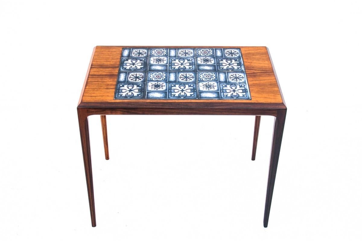 Teak coffee/side table with ceramic top.

Manufactured in the mid-20th century in Denmark. A small coffee table, ideal even for small rooms. The simple, minimalist form has been broken by a ceramic element on the top.

The furniture is in very good