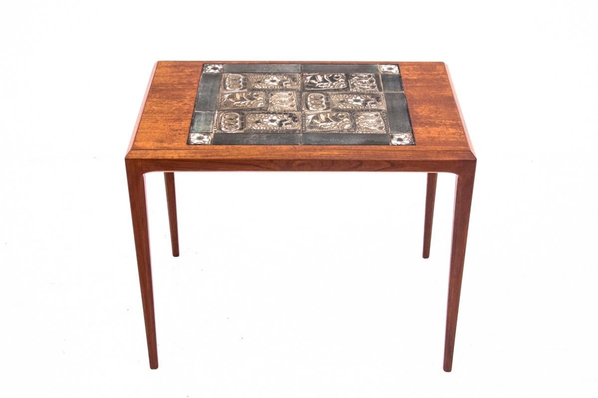 Teak coffee/side table with ceramic top.

Manufactured in the mid-20th century in Denmark. A small coffee table, ideal even for small rooms. The simple, minimalist form has been broken by a ceramic element on the top.

The furniture is in very good