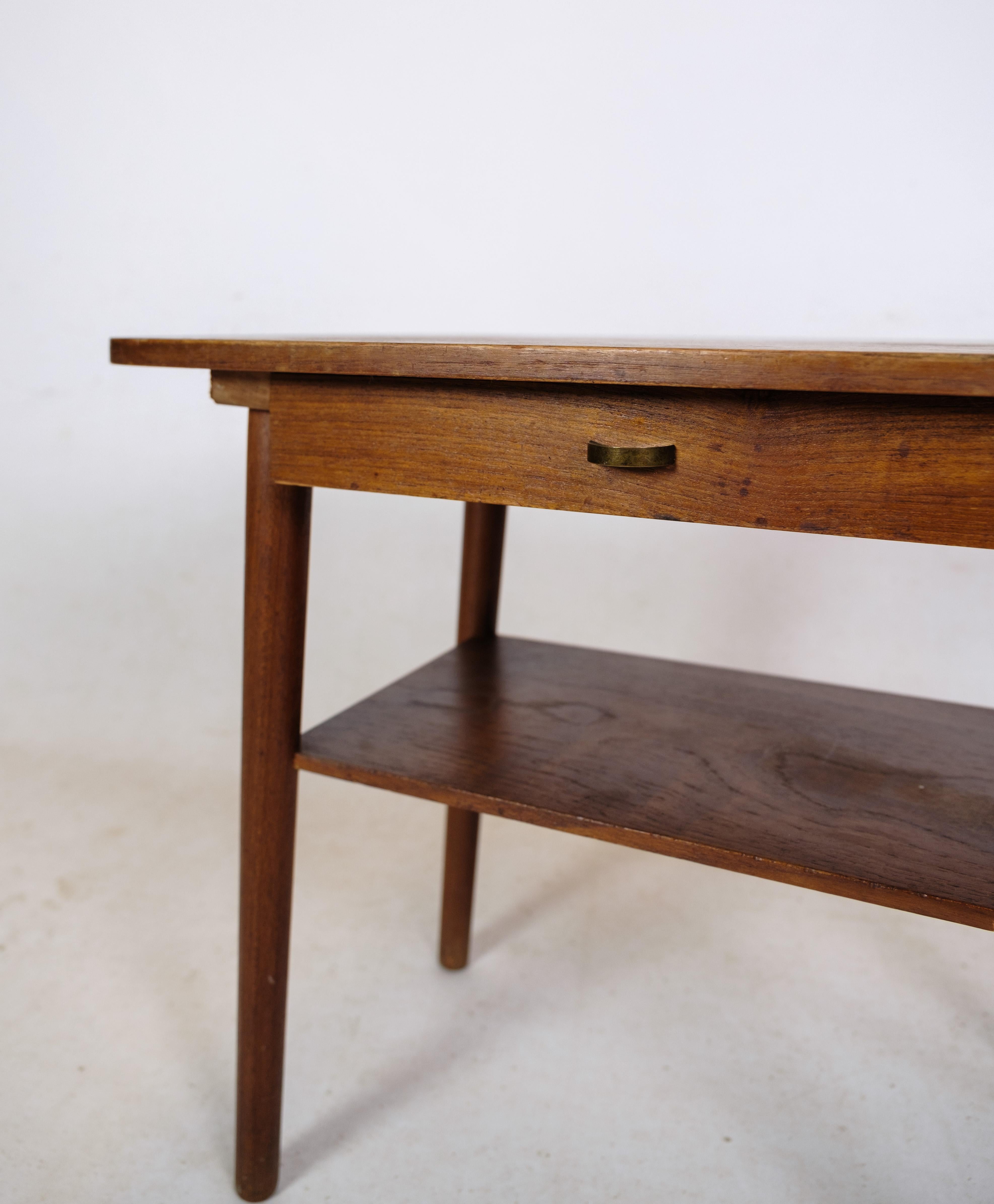Table d'appoint / table de chevet avec tiroir et étagère en bois de teck de design danois des années 1960 environ.
Mesures en cm : H:48 L:59 P:39.5