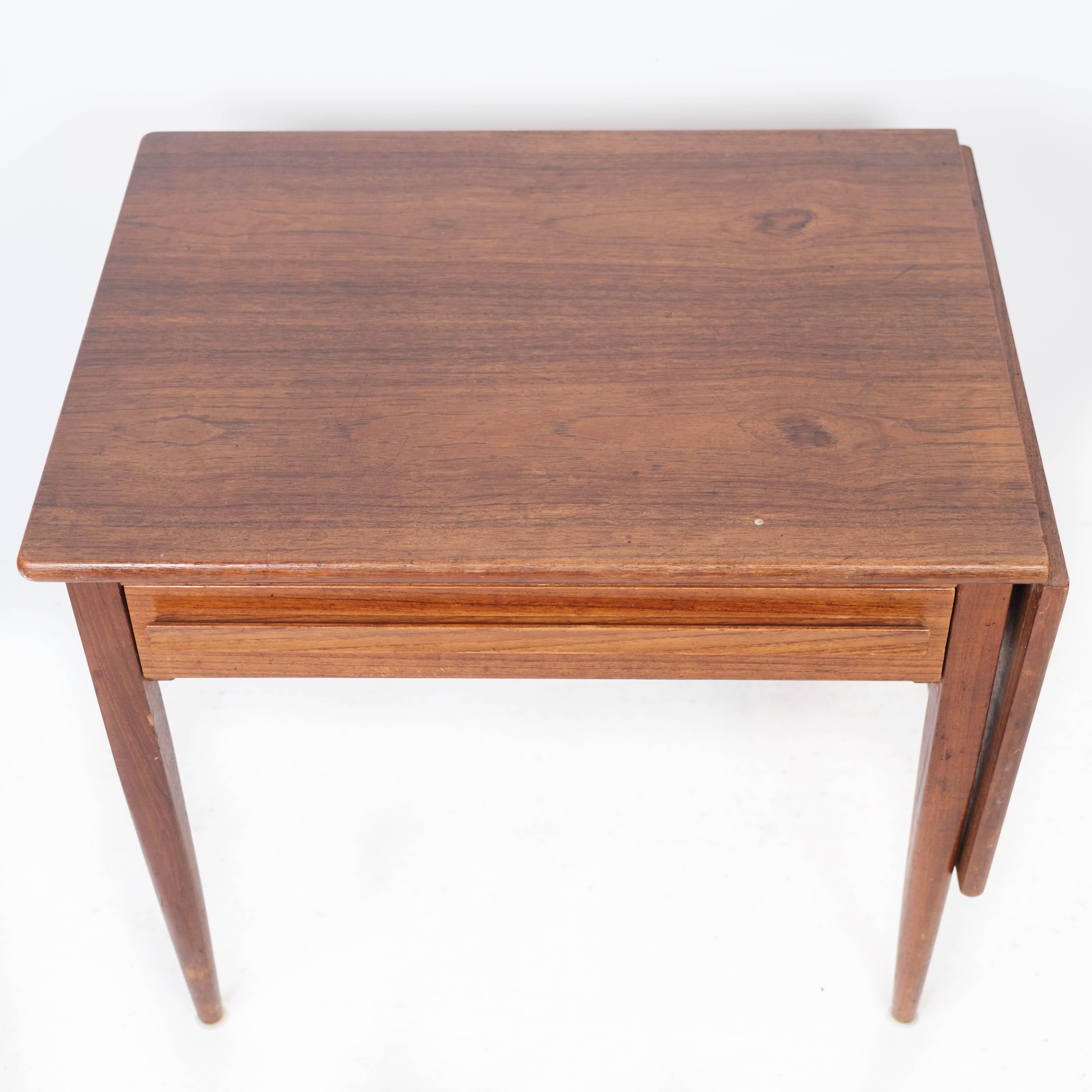 La table d'appoint à abattants, fabriquée en teck de design danois par Silkeborg Møbelfabrik dans les années 1960, est un meuble charmant et fonctionnel au look scandinave classique.

Les tons chauds du bois de teck et son magnifique motif naturel