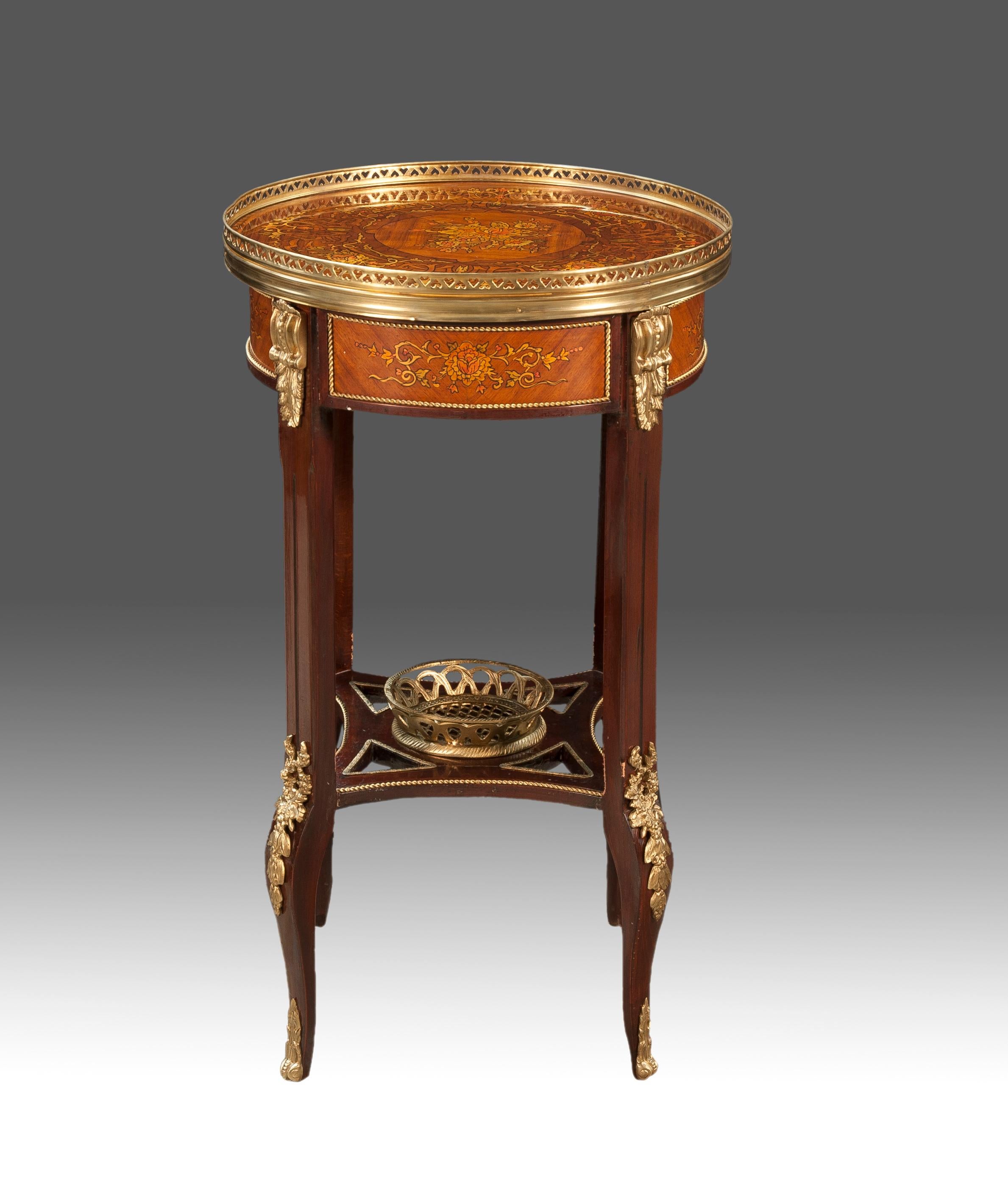 Side table. Wood, marquetry, gilded metal.
Circular side table with four cabriole legs at the bottom and straight from the legs at the bottom and straight from the tabletop that acts as a The tabletop acts as a screen (on which there is an openwork