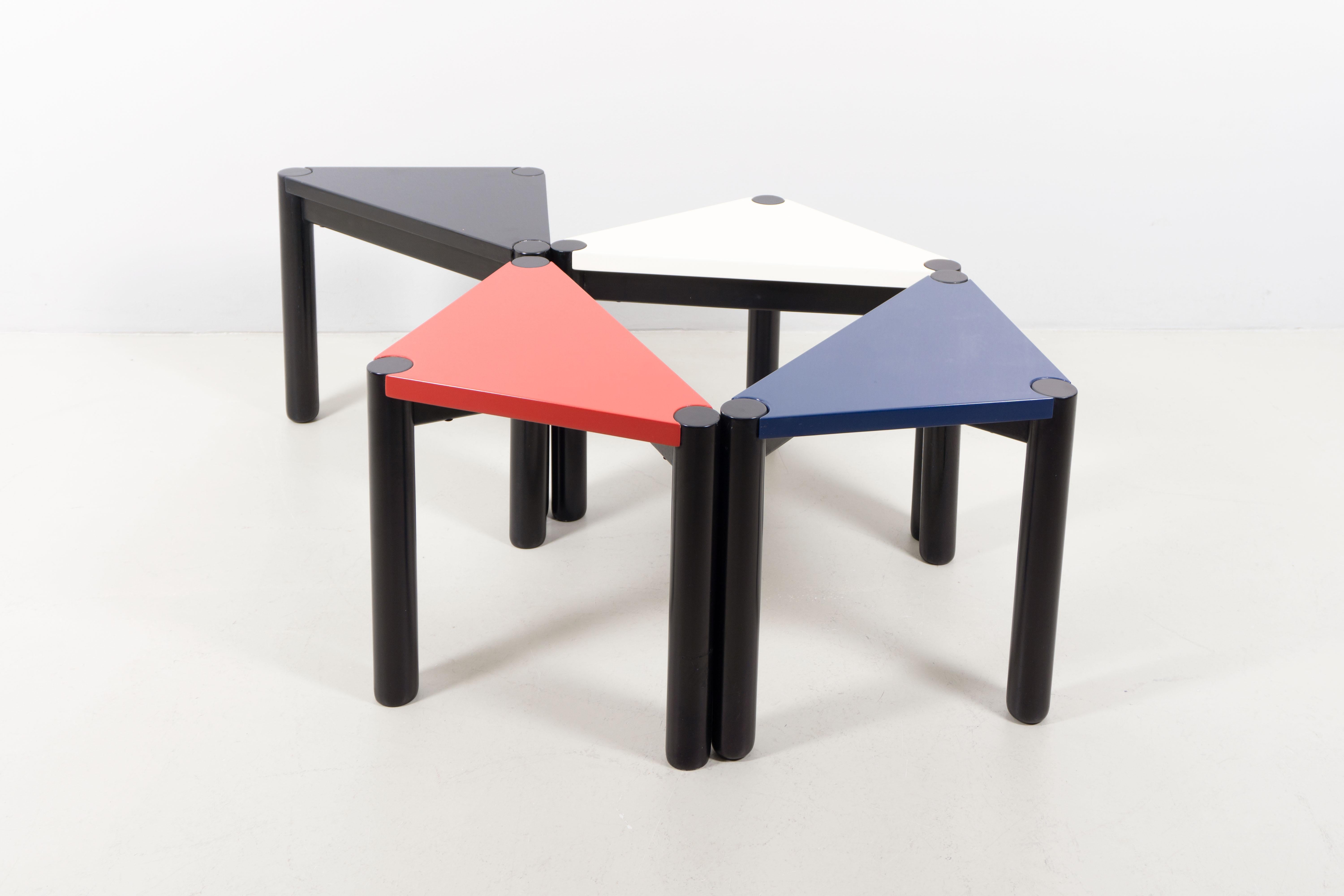 Vier Tische, entworfen von Ico Parisi um das Jahr 1970. Jeder Tisch ist aus Holz gefertigt und in verschiedenen Farben lackiert: weiß, rot, marine und schwarz. Parisi vereint mit diesen Tischen spielerisches und rationales Design. Sie laden die