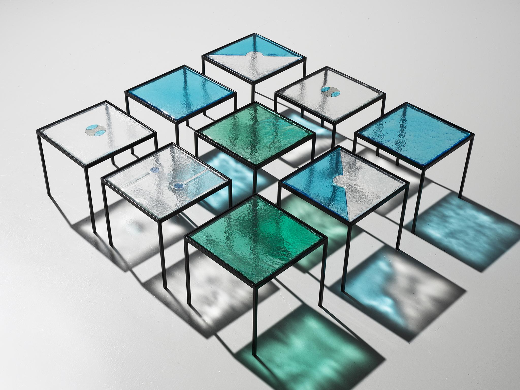 Side tables, blue, green and transparent glass and steel, Europe, 1980s.

These side tables are both playful in its aesthetics and solid in its construction. They all feature a different top of structured glass yet, when placed together, form an