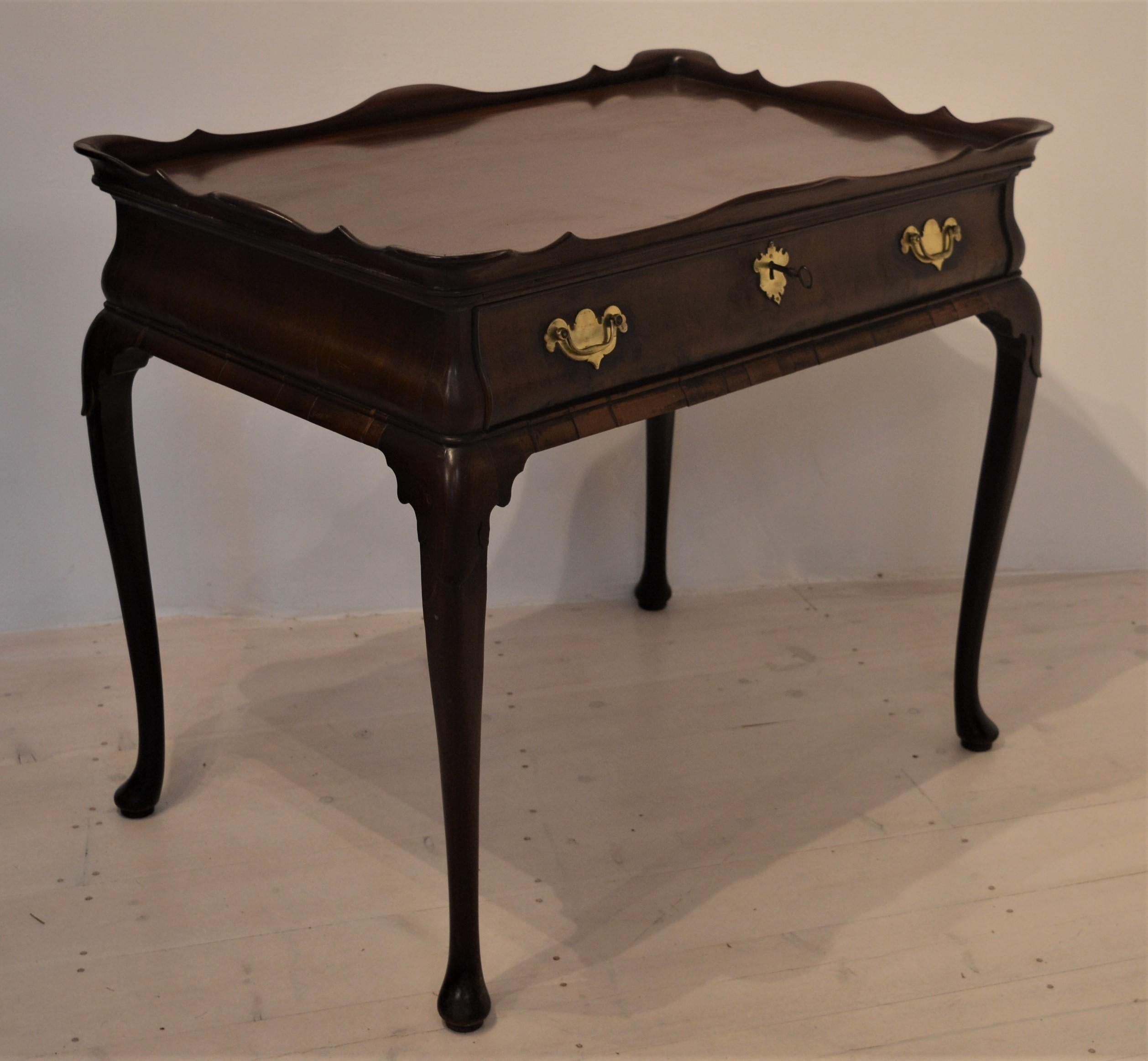 Superb 18th century mahogany side table with raised and decorated frieze which identifies it as an original Georgian tea table. This elegant piece of furniture has tear drop cabriole legs all around and a finished back so that it can be centre