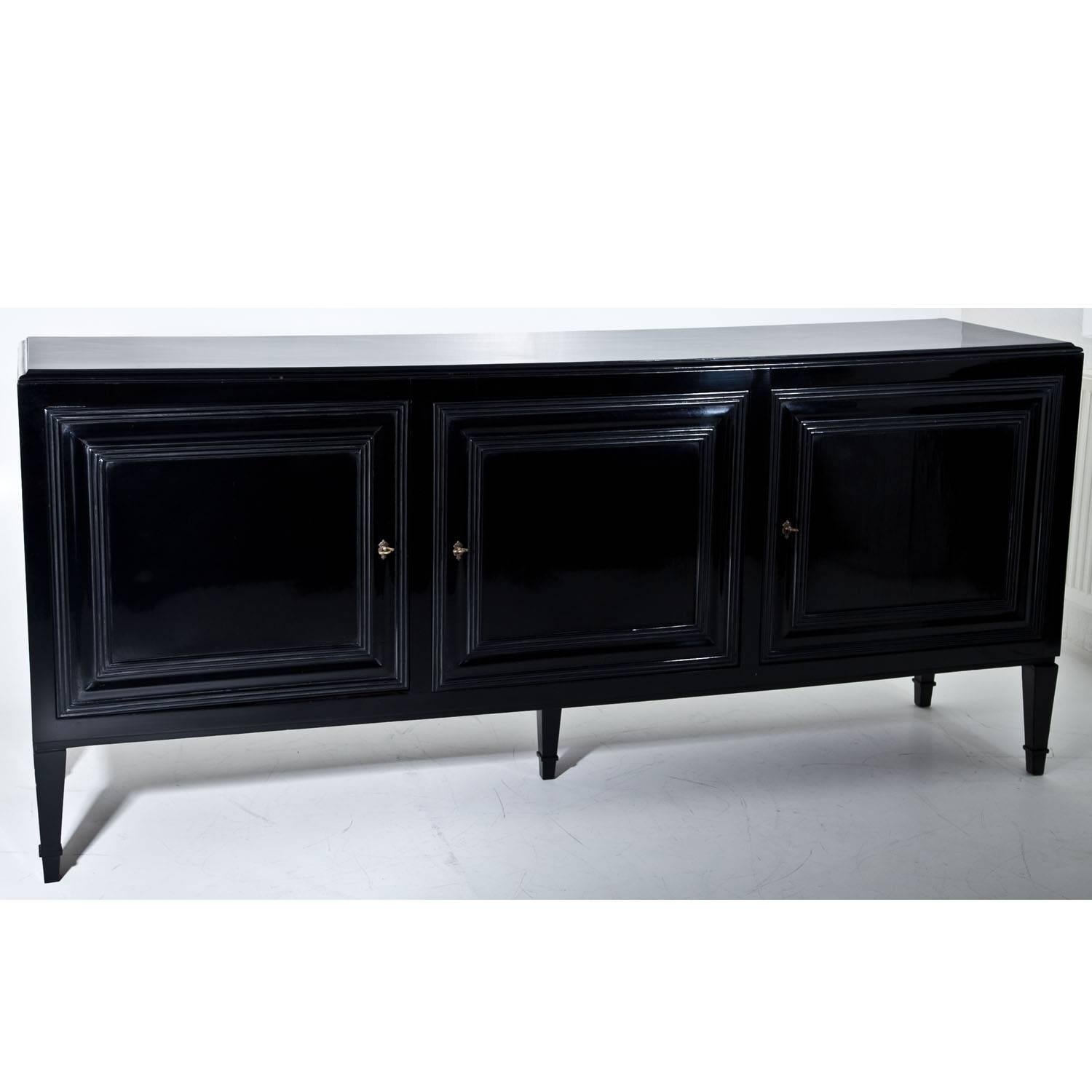 Large sideboard with three doors standing on tapered feet with fillings at the front. The doors and the upper edge show nice moldings. The sideboard was later ebonized.