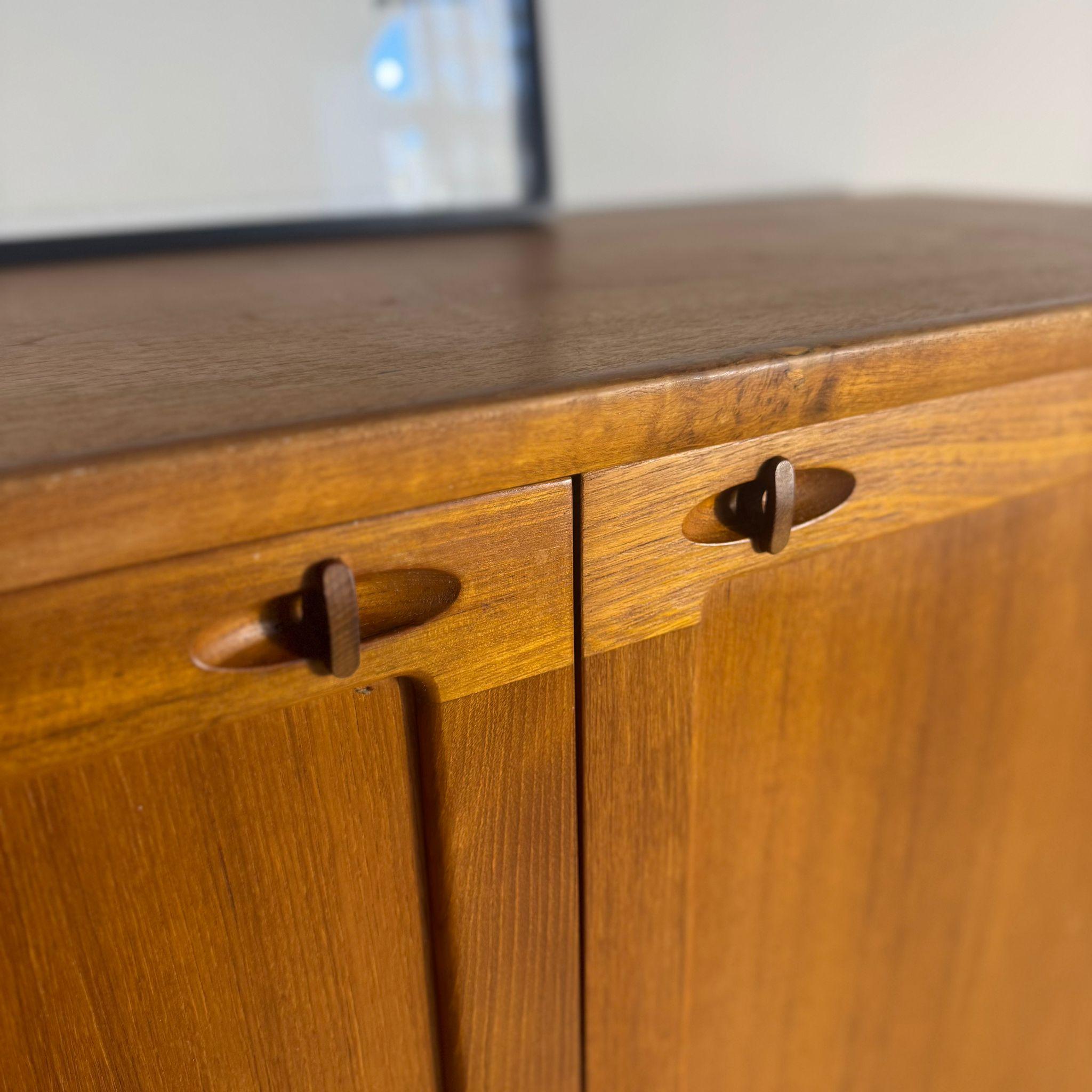 Questa raffinata credenza alta in teak impiallacciato, disegnata da H.W. Klein per Bramin, rappresenta una delle espressioni più eleganti del design danese degli anni Sessanta. Le sue linee pulite e proporzionate raccontano il modernismo scandinavo