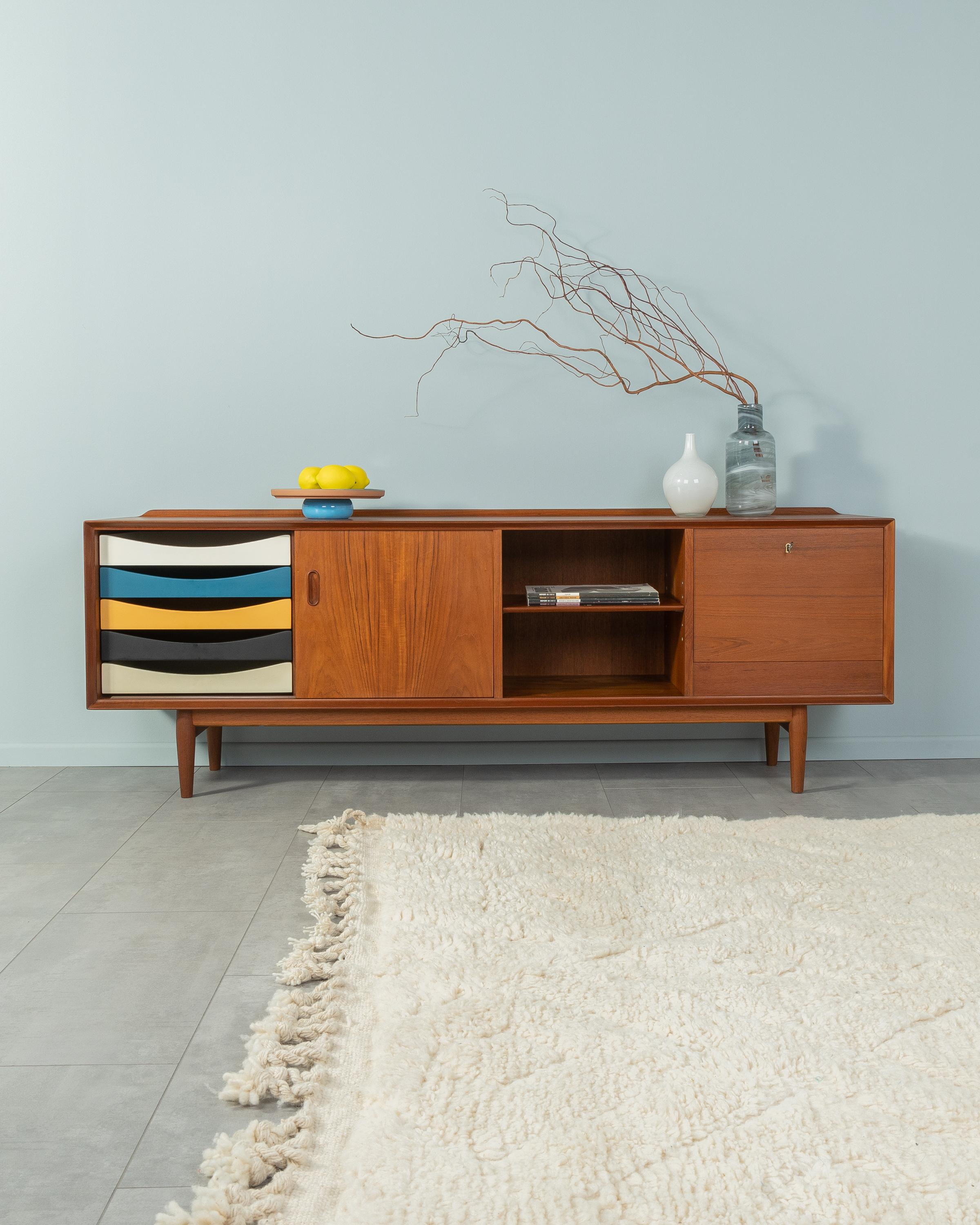 Exclusive sideboard, model OS35, by Arne Vodder for Sibast. High-quality corpus in teak veneer with five colored drawers, a sliding door, an extension, a shelf, a hinged door and cigar shaped feet.
Quality Features:

 accomplished design: perfect