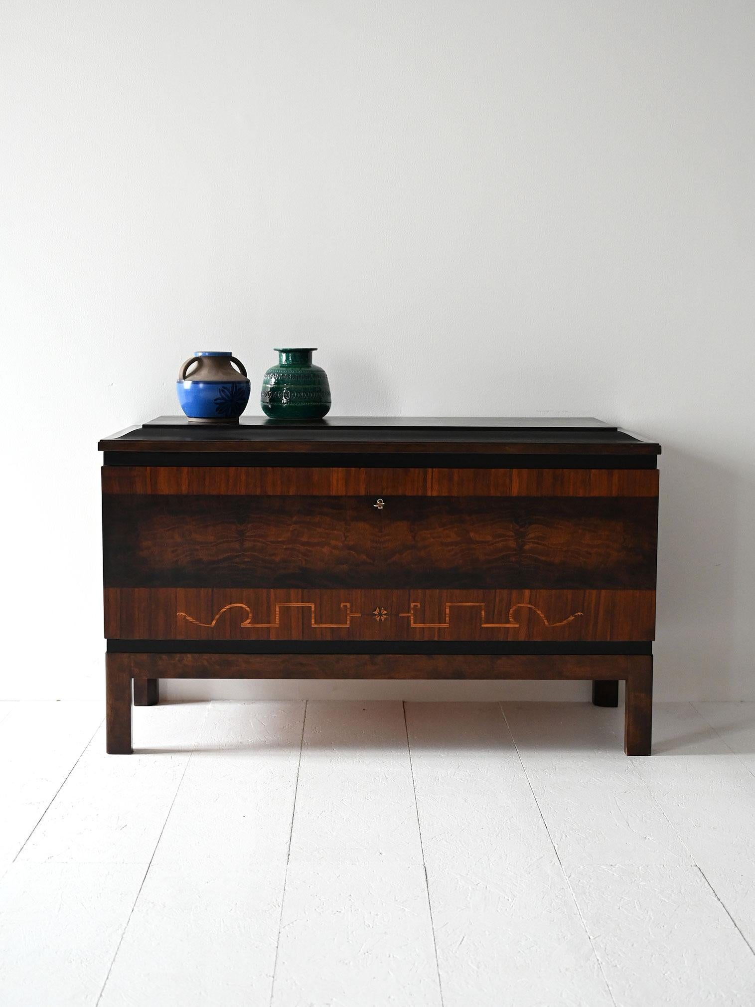 Sideboard anni ’30 in radica di legni misti, con anta a battente frontale, mensole interne e cassetti laterali.

Sideboard Art Decó scandinavo risalente agli anni ’30, realizzato in radica di legni misti con venature profonde e intarsi decorativi