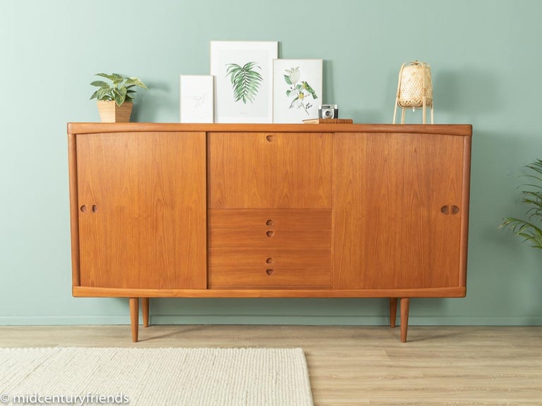 Classic highboard from the 1960s. High quality corpus in teak veneer with two sliding doors, four drawers, a hinged compartment, five shelves and cigar shaped feet.
Quality Features:

 Accoplished design: perfect proportions and recognizable