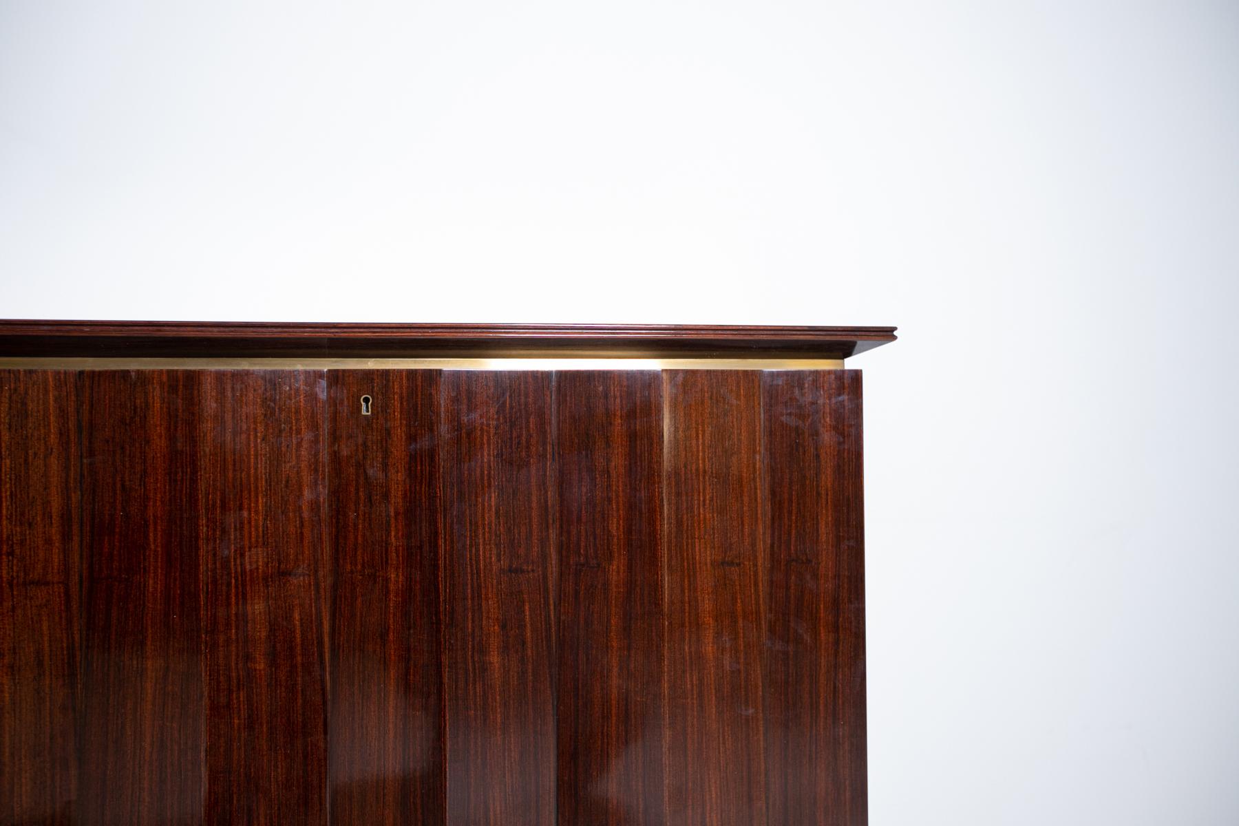 Important sideboard by Melchiorre Bega from the 1950s. The sideboard is made of precious woods. The peculiarity of the furniture is its processing of the doors, each door is made with a pyramid-shaped processing with wavy pattern. Under the shelf