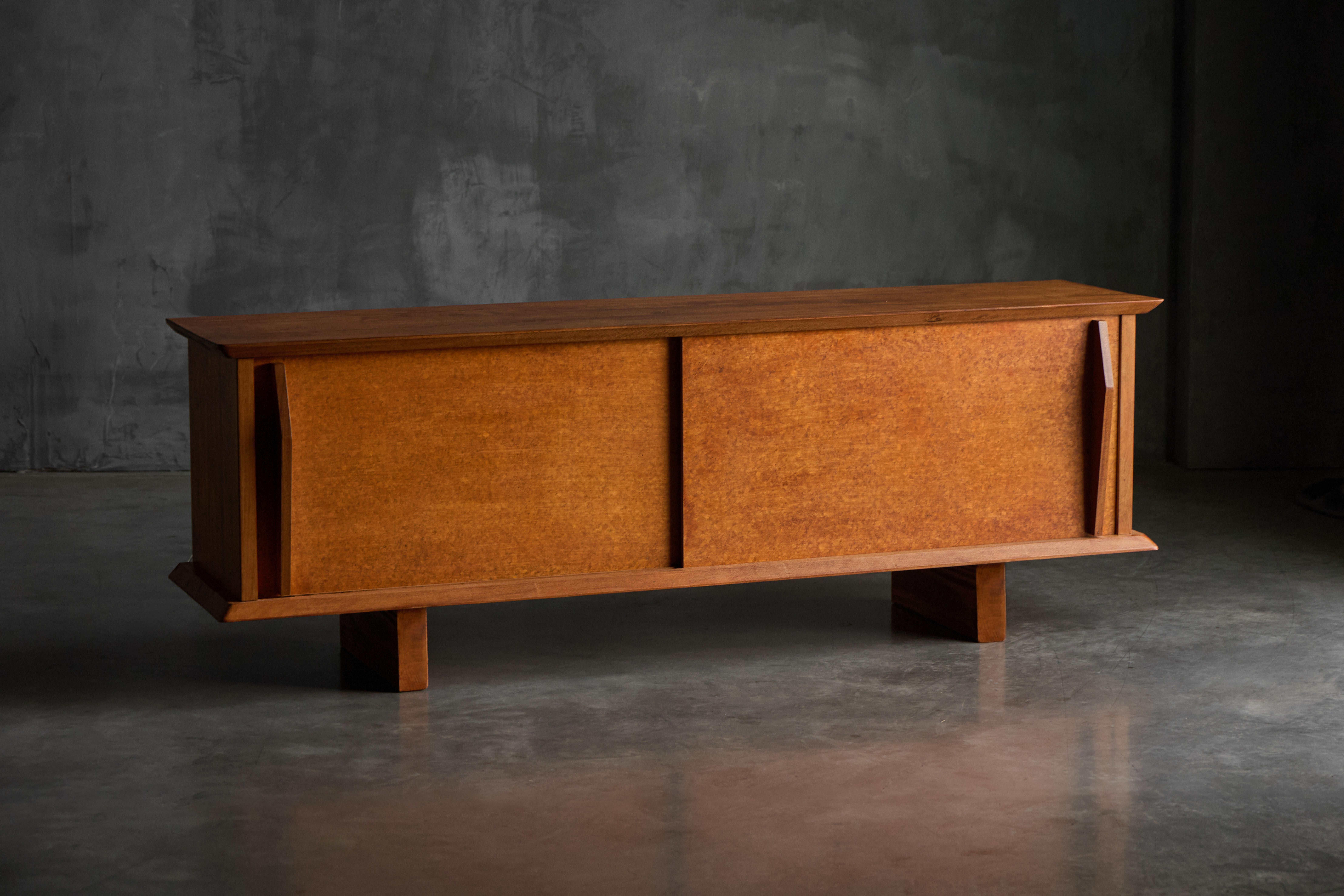 Ein seltenes zweitüriges Buffet aus dem Jahr 1954, entworfen von Charlotte Perriand in Collaboration mit dem Atelier Jean Prouvé. Auf einem massiven Holzgehäuse montiert, verkörpert dieses Stück den raffinierten Minimalismus und die architektonische