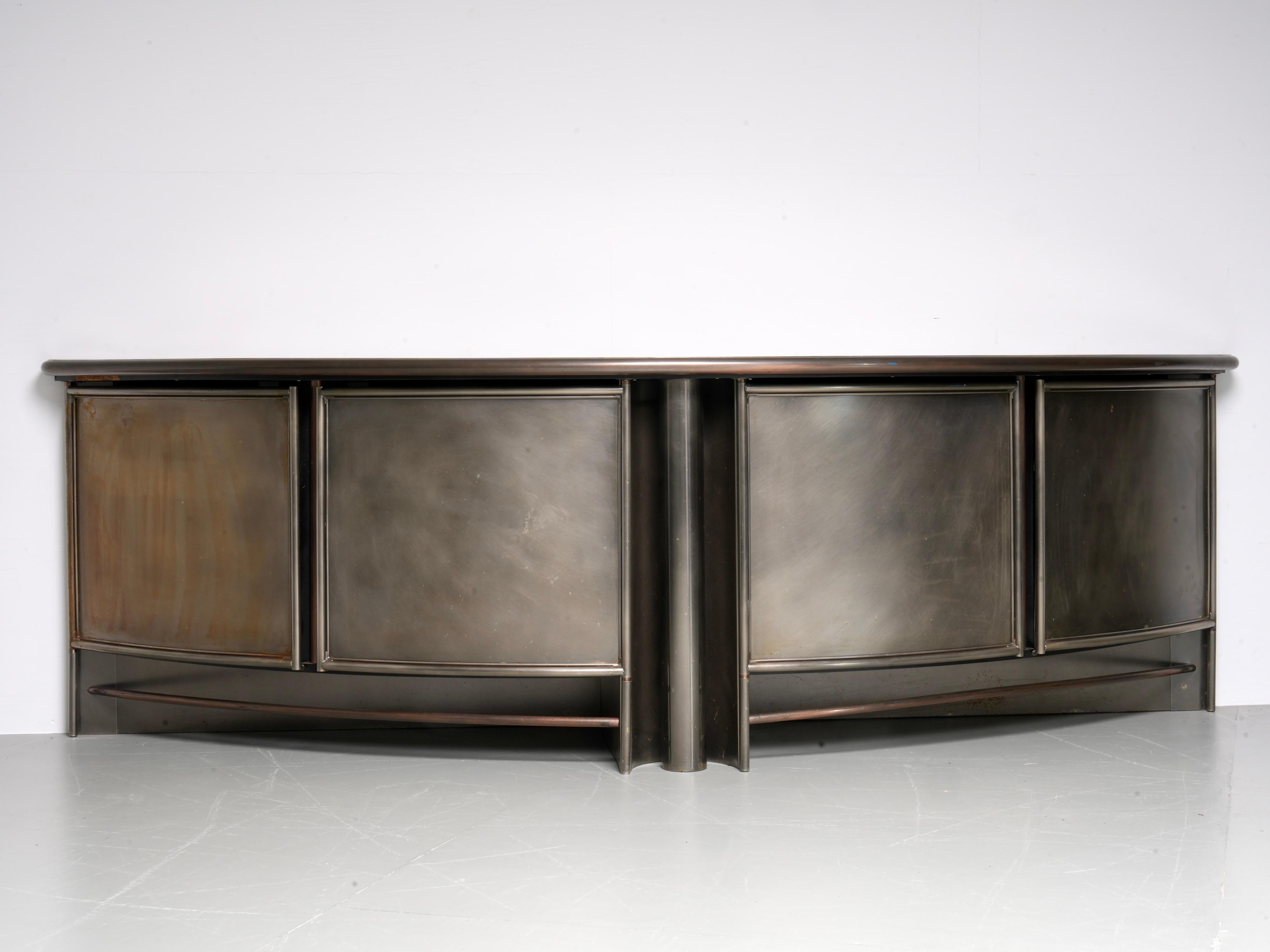 Credenza di Frans van Praet per Belgochrom, Belgio, anni '80

Questa credenza semicircolare è realizzata in metallo scurito con una superficie spazzolata che le conferisce una sottile patina. Il fronte curvo è composto da più porte con pannelli