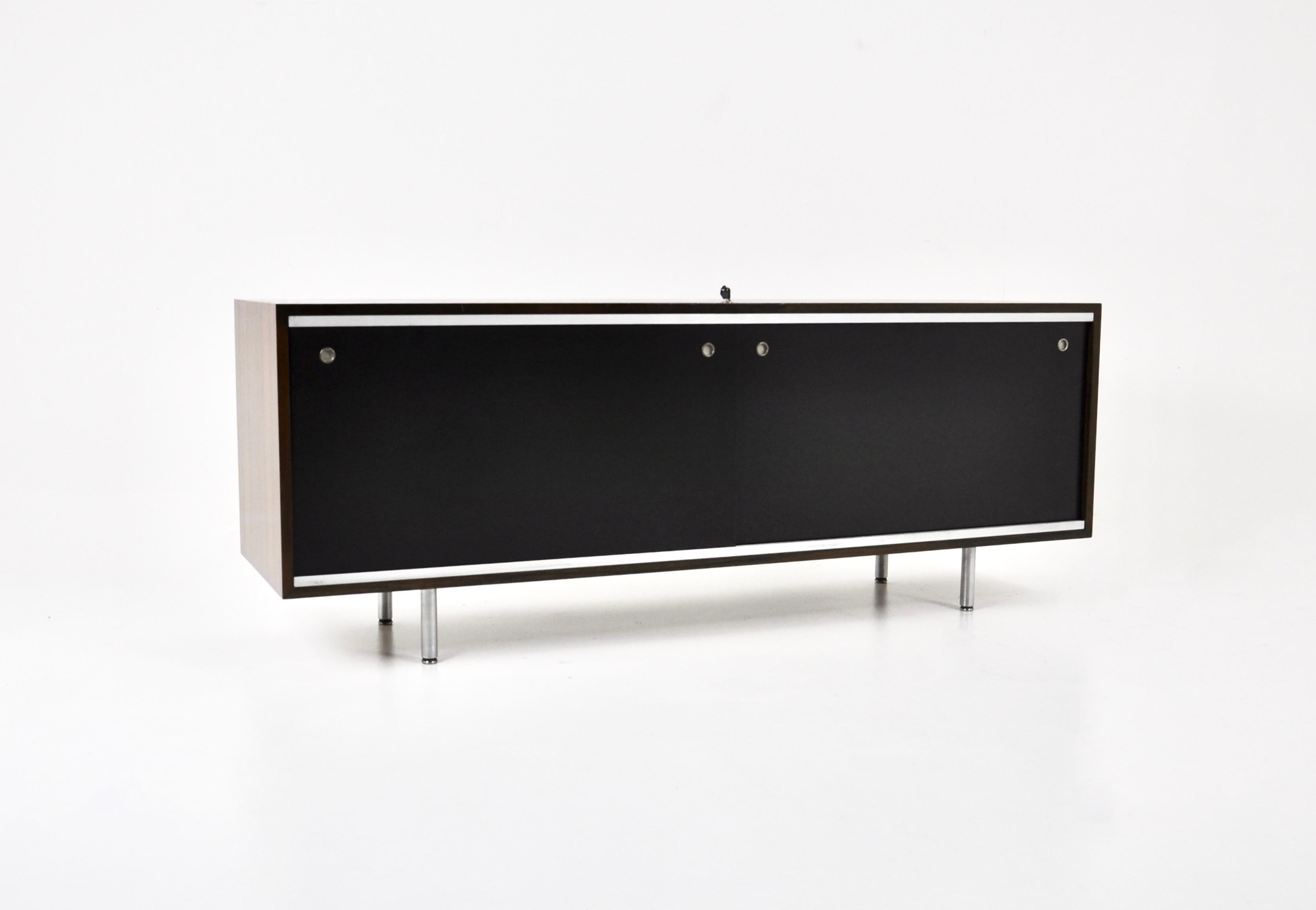 Sideboard aus Holz mit 2 schwarzen Schiebetüren, die jeweils höhenverstellbare Einlegeböden und abschließbare Türen enthalten, entworfen von George Nelson. Zeit- und altersbedingte Abnutzung.
Für den Versand, fragen Sie uns für den besten Preis zu