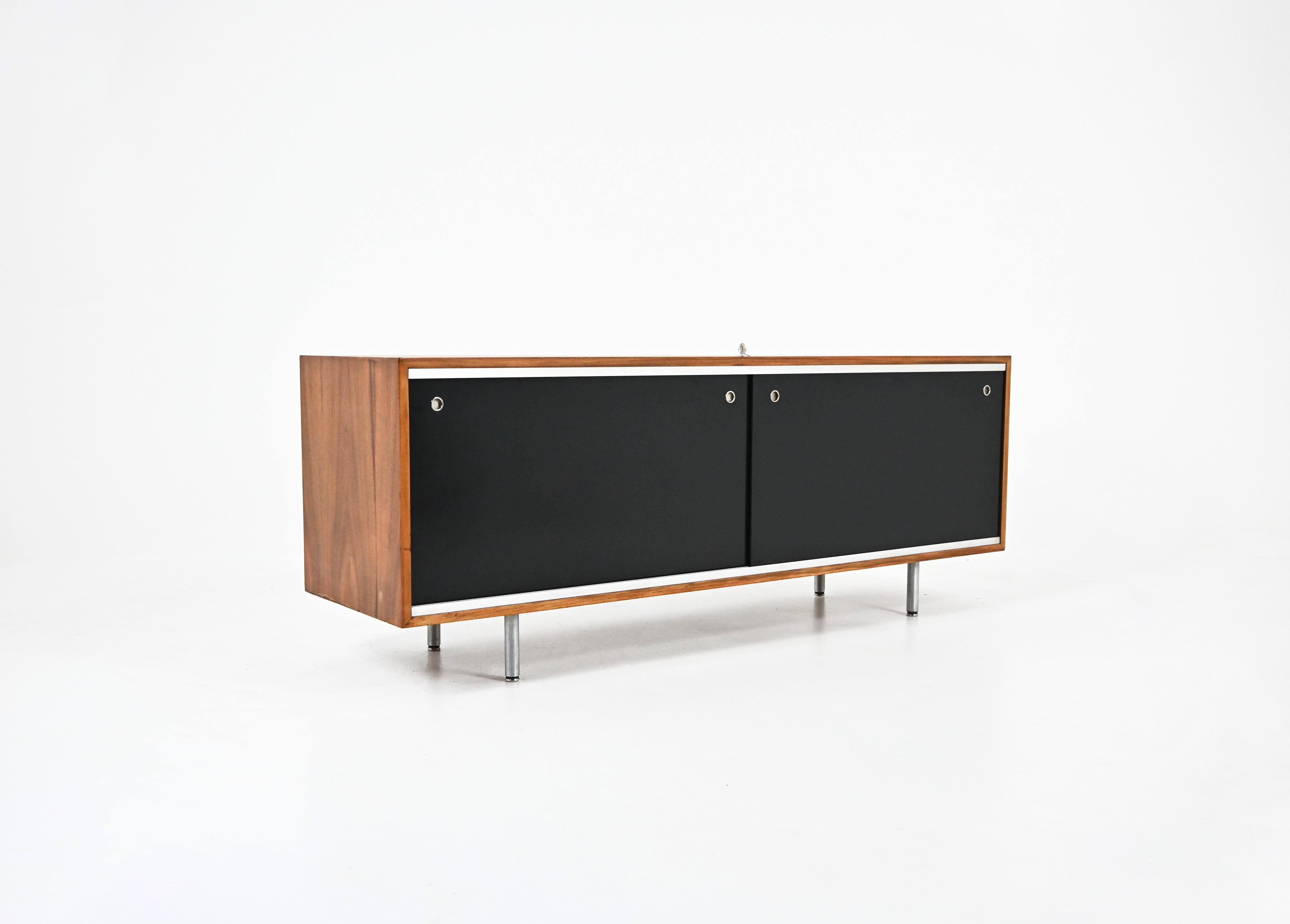 Wooden sideboard with 2 black sliding doors, each containing height-adjustable shelves and one door that can be locked designed by George Nelson. Wear due to time and age.
FOR SHIPPING, REQUEST US FOR RECEIVE THE BEST PRICE
