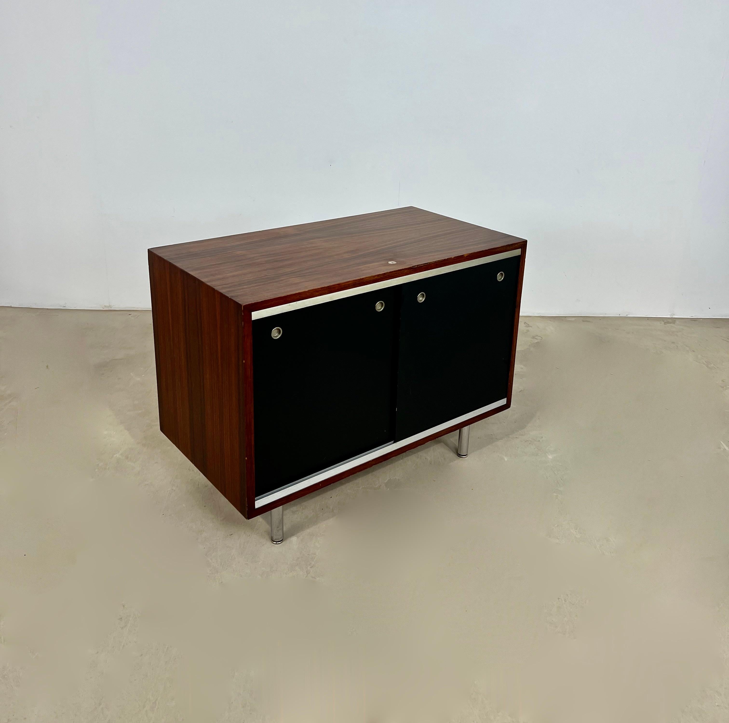 Side board composed of two sliding doors of black color. Foot in metal. No key. Wear due to time and lage of the sideboard.