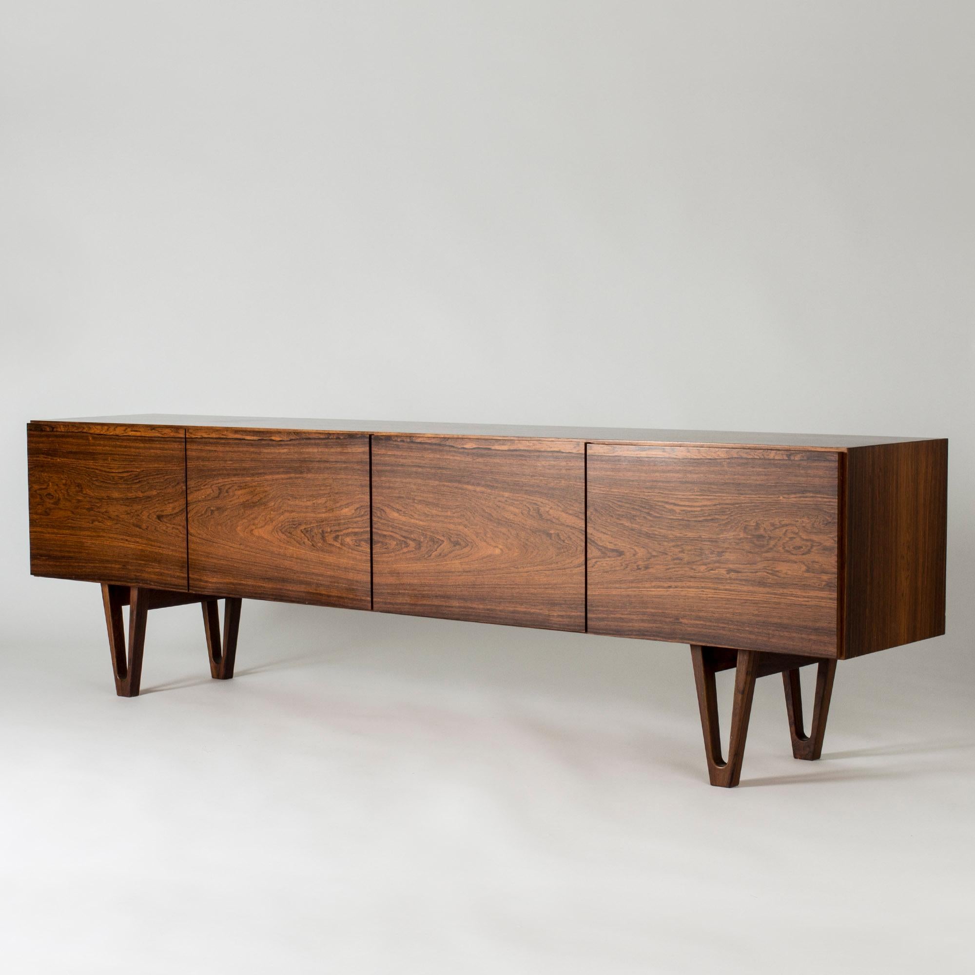 Stunning rosewood sideboard by Ib Kofod Larsen for the Swedish firm Seffle Möbelfabrik, made in the late 1950s. Low design that gives the impression that the sideboard is extra long. Beautifully sculpted legs and carefully hollowed out discreet