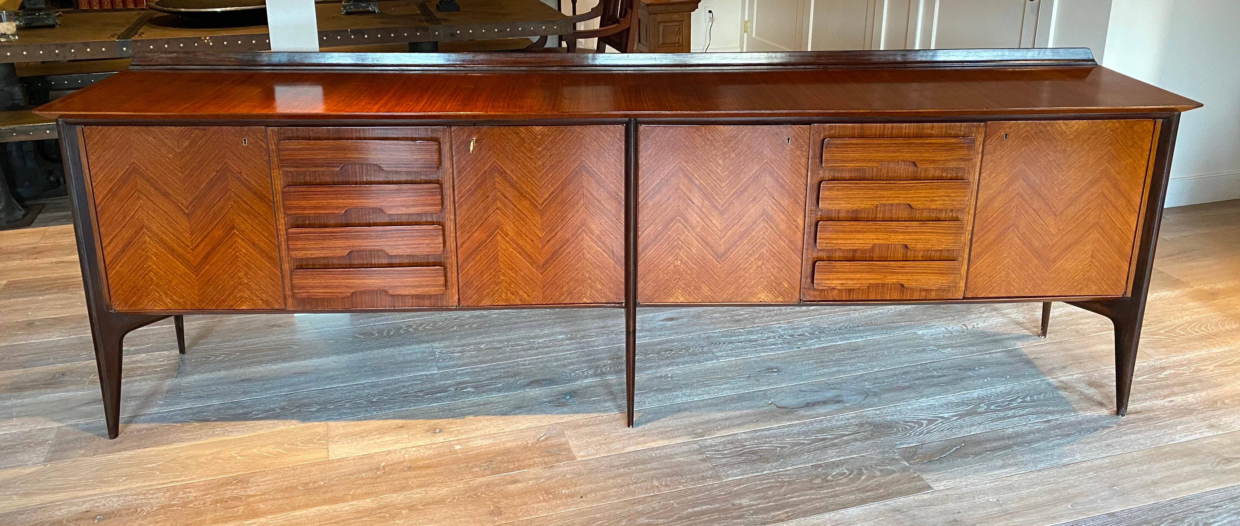 An important sideboard by Italian designer Ico Parisi. Designed in 1948 with structure in walnut wood, ebonized wood and veneered wood. Features herringbone detailing, two series of false drawers and internal drawers with brass handles. Includes