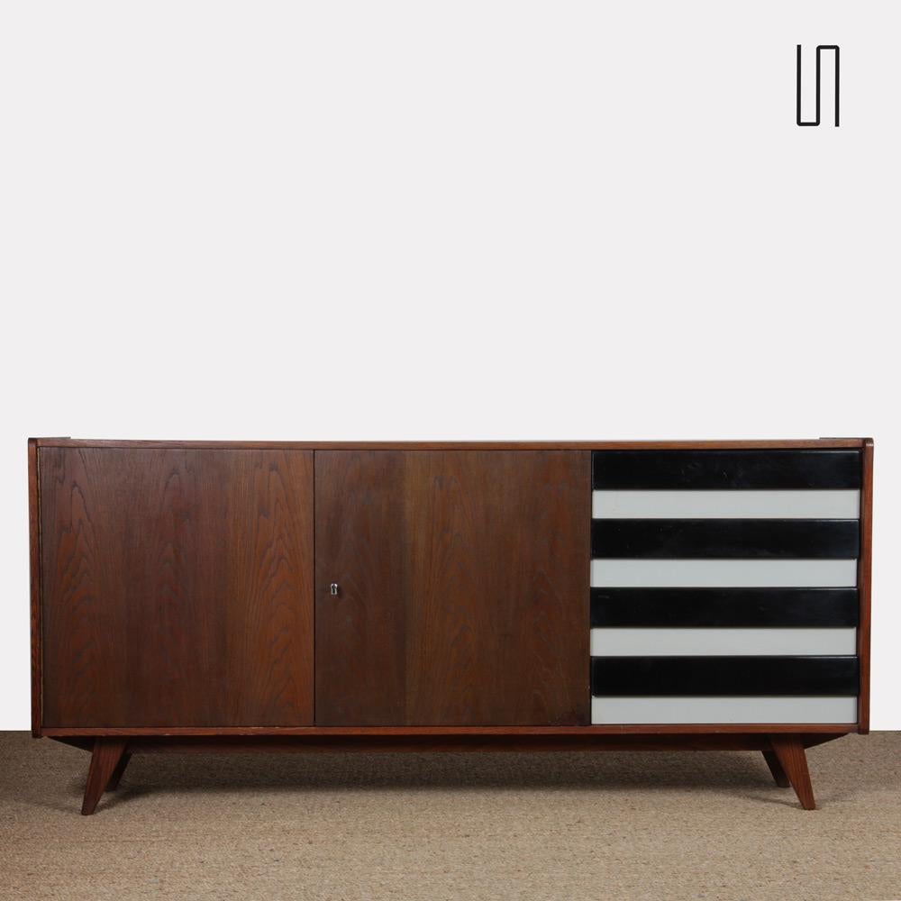 Esta enfilada es obra del diseñador Jiri Jiroutek para Interier Praha hacia 1960. Es el modelo U-460 de la República Checa. Este mueble de roble teñido incluye un juego de 4 cajones de plástico. Este mueble de madera está en buen estado vintage. La
