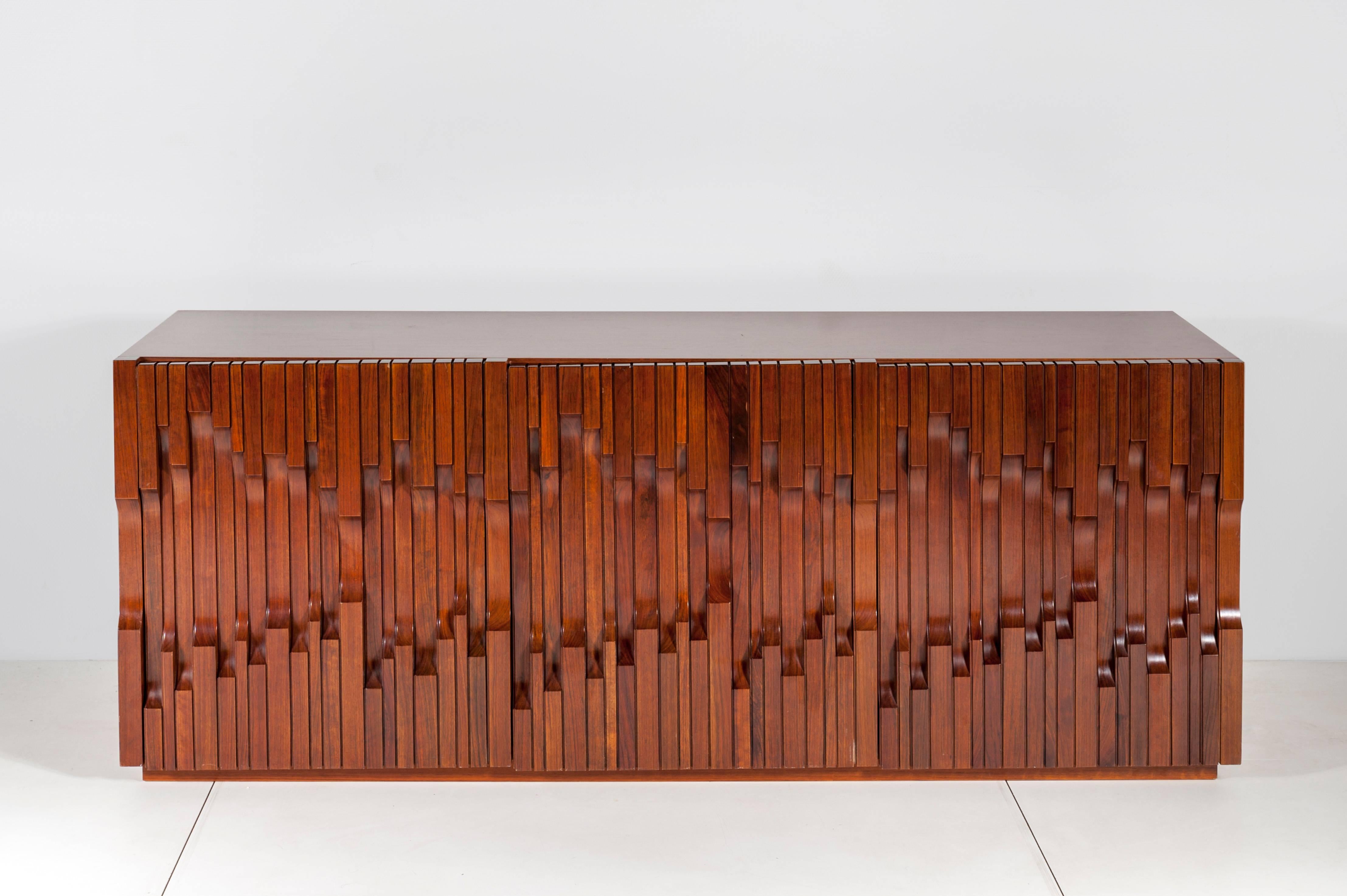 Sideboard three-door african walnut veneer « Norman » model, designed by Luciano Frigerio. Shelf and drawer system inside. Manufactured in Desio, Italy, circa 1972, signed on the side.
Luciano Frigerio (1929-1999) was the son of a family of healers