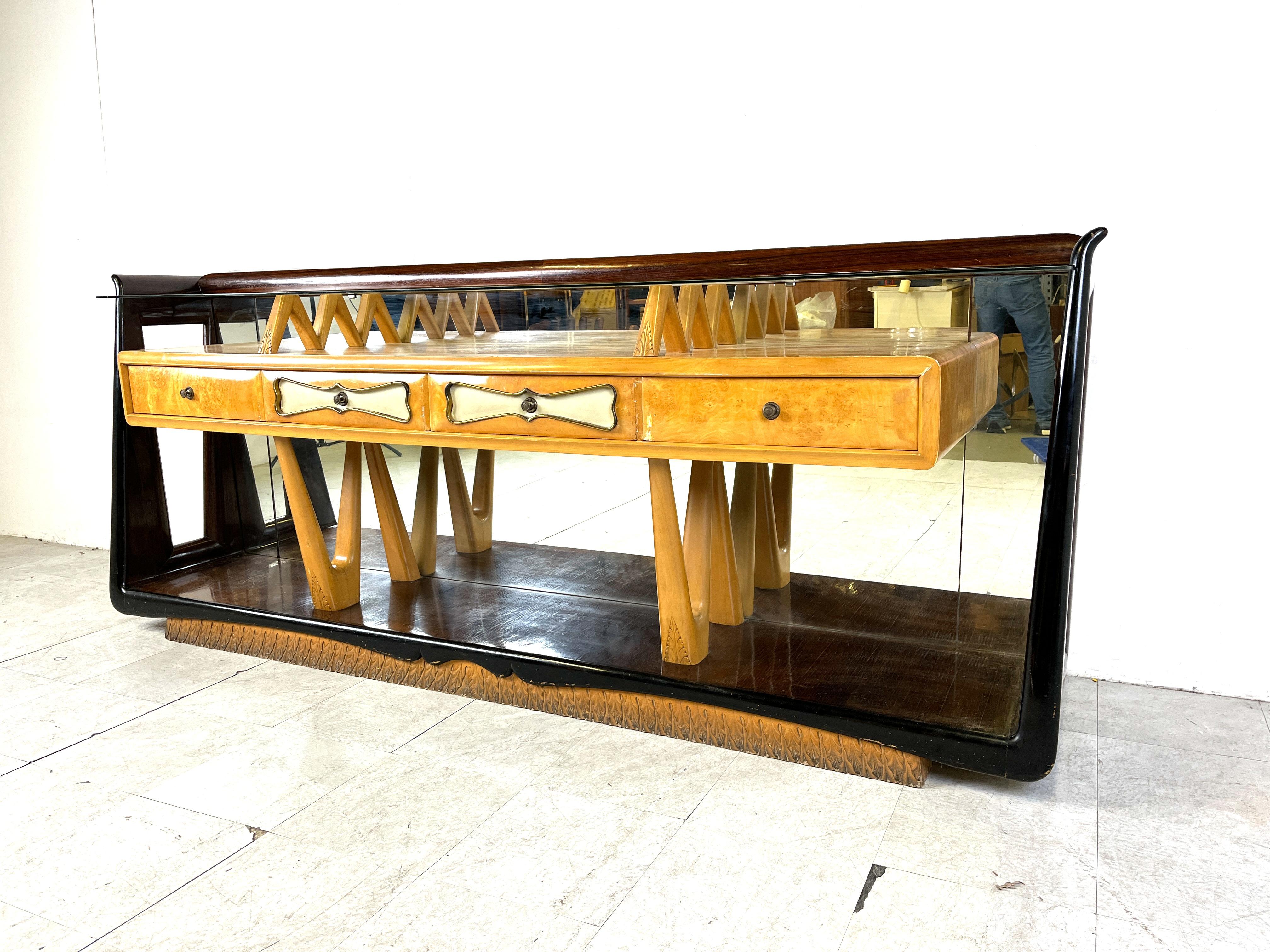 Mid century modern italian sideboard by Osvaldo Borsani featuring made from rosewood, maple wood and mirror.

The maple wooden case features 4 drawes with brass details and handles.

The case is supported by finely crafted legs which also come back