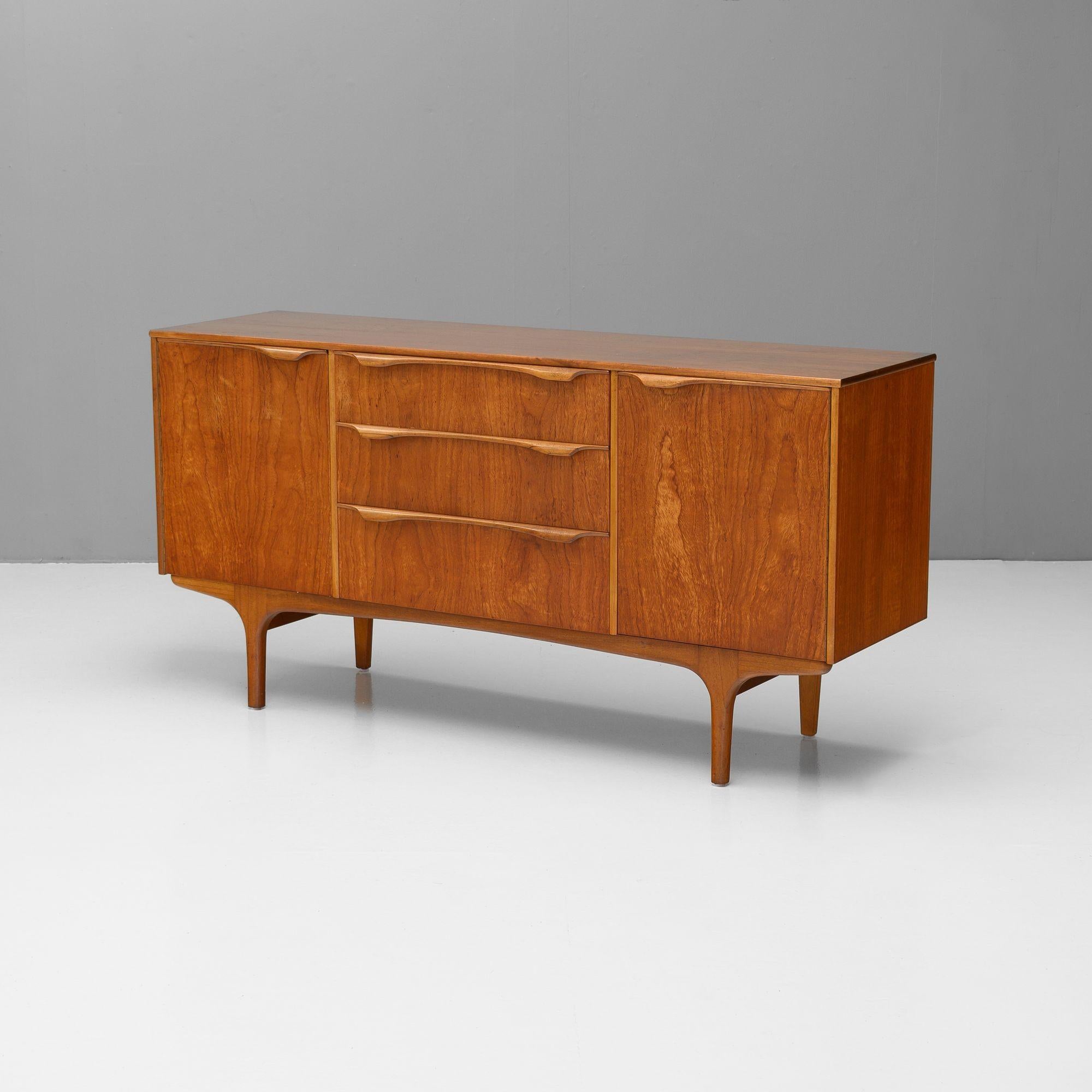 Petite sideboard by Scottish maker Sutcliffe Todmoren. Three drawers flanked by two shelved cupboards. Re-finished.

U.K circa 1960.

H 77cm x W 152cm x D 45cm