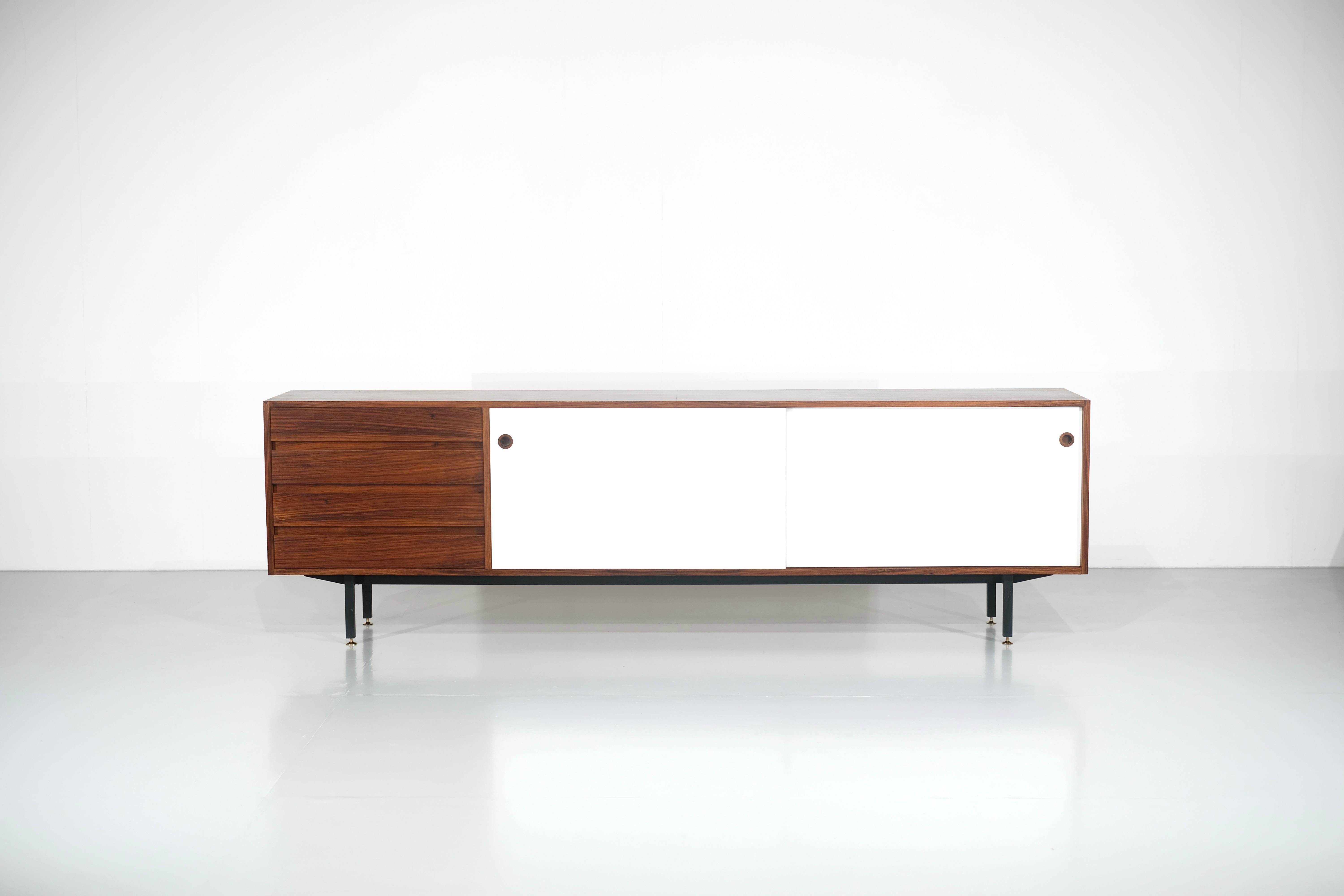 Buffet en bois avec 2 portes coulissantes stratifiées en Formica blanc, 4 tiroirs en bois massif et pieds en acier, restauration complète.

Conçu par Walter Wirz, fabriqué par Wilhelm Renz, fabriqué en Allemagne à partir des années 1960. 

