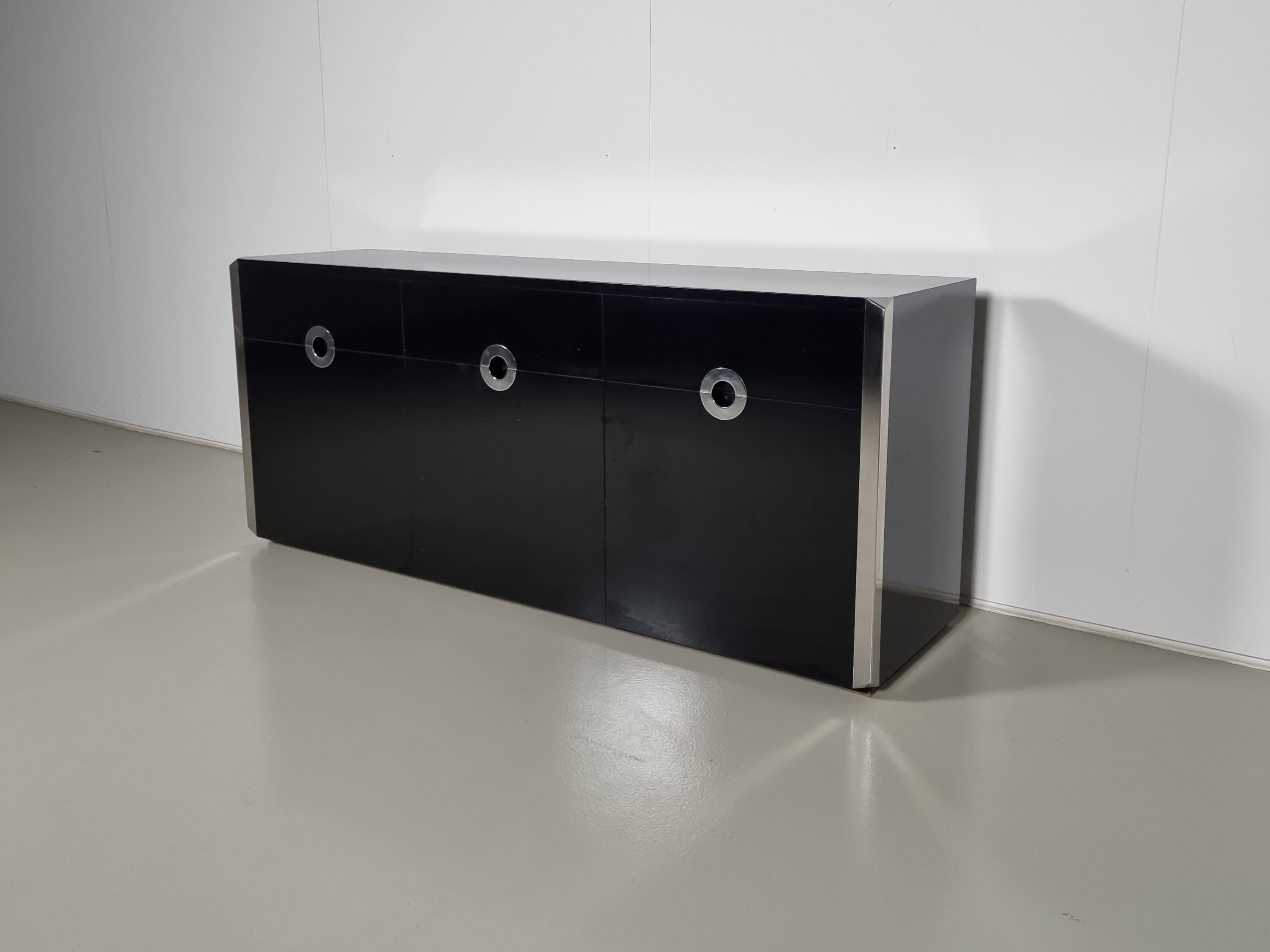 Elegant black sideboard made in black laminated wood and chromed steel edges and drawer pulls on the front. Designed by Willy Rizzo for Mario Sabot in Italy in 1974. It has two opening side doors, one center drop-down door, and three drawers. The