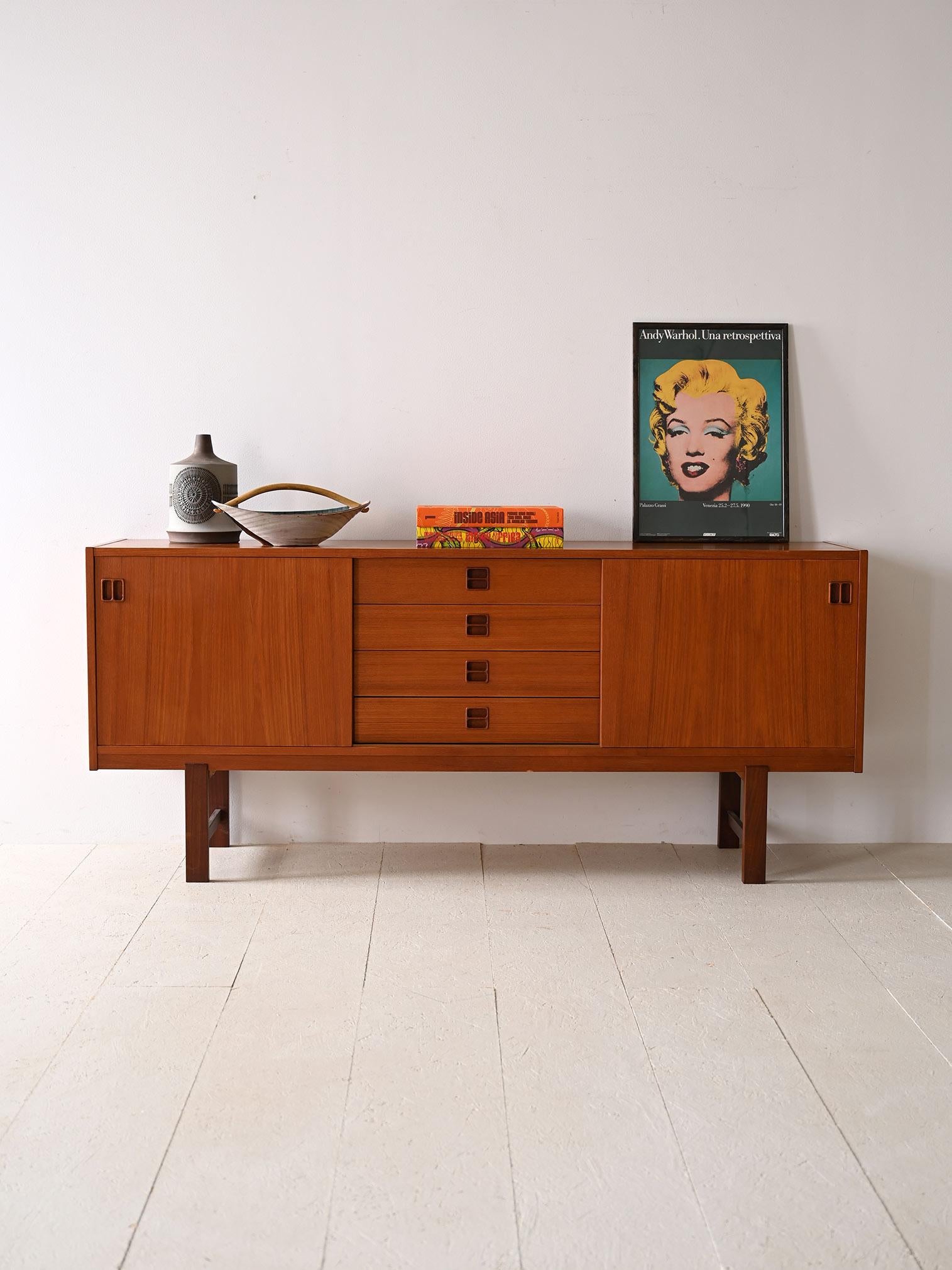1960s teak sideboard with sliding doors and 4 drawers. 

This elegant piece of furniture perfectly embodies the minimalist and rationalist aesthetics of the period with its clean, linear structure. Made of teak wood, the sideboard exudes warmth and