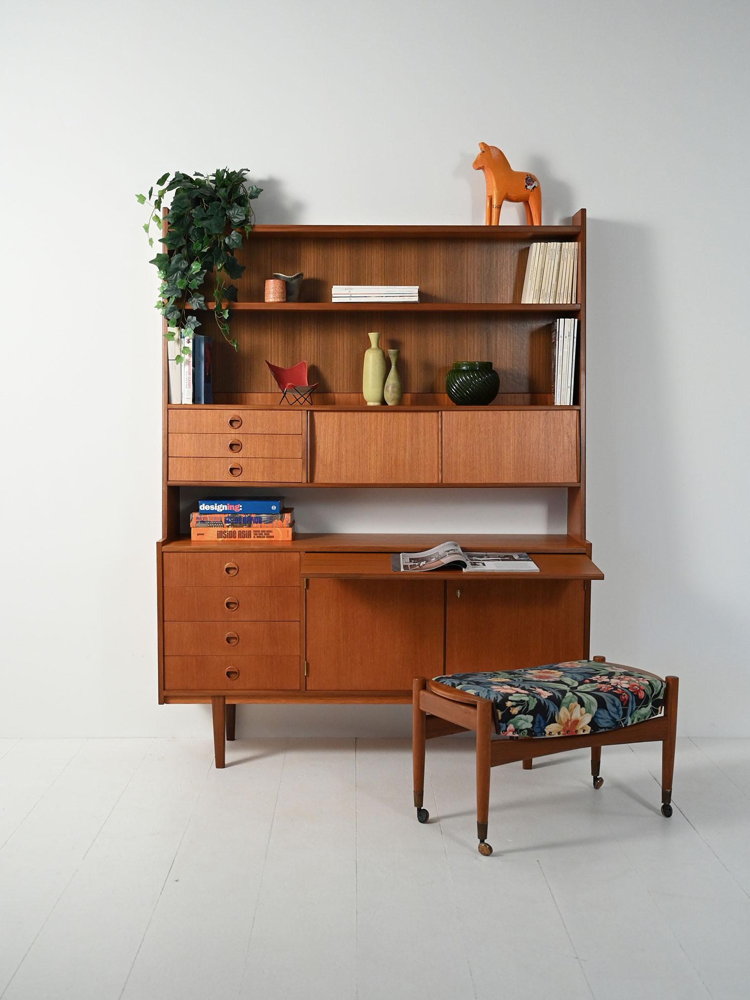 Sideboard-libreria scandinava anni ’60 in teak e mogano: cassetti laterali, vani con mensole interne, scrivania estraibile e mensole a vista.

Sideboard con libreria scandinava anni ’60 impiallacciata in teak, con schienale superiore in parte aperto