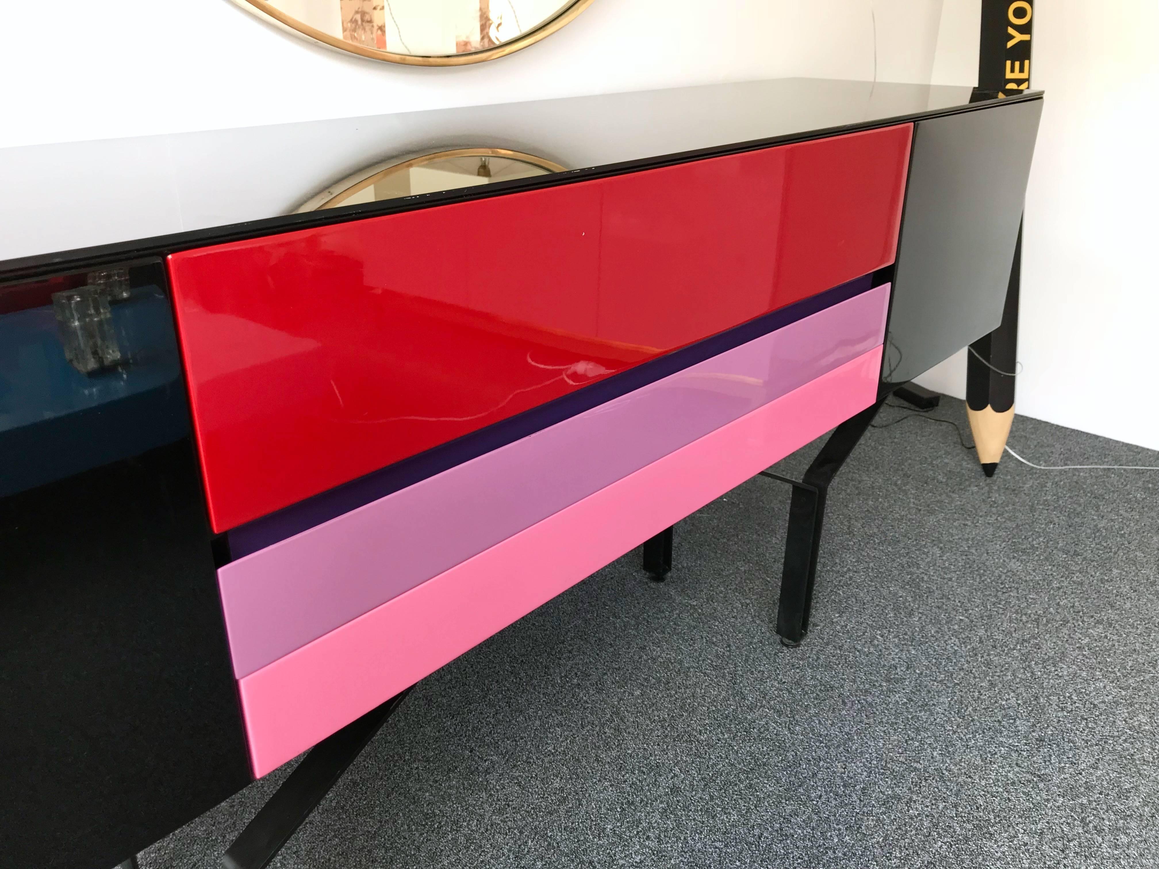 Sideboard buffet credenza or console table attributed to the Italian editor Acerbis. Three drawers and two doors lacquered red, pink, parma purple light and black. Black opalin top glass. Black metal feet. Same period as Memphis, Archizoom, Giotto