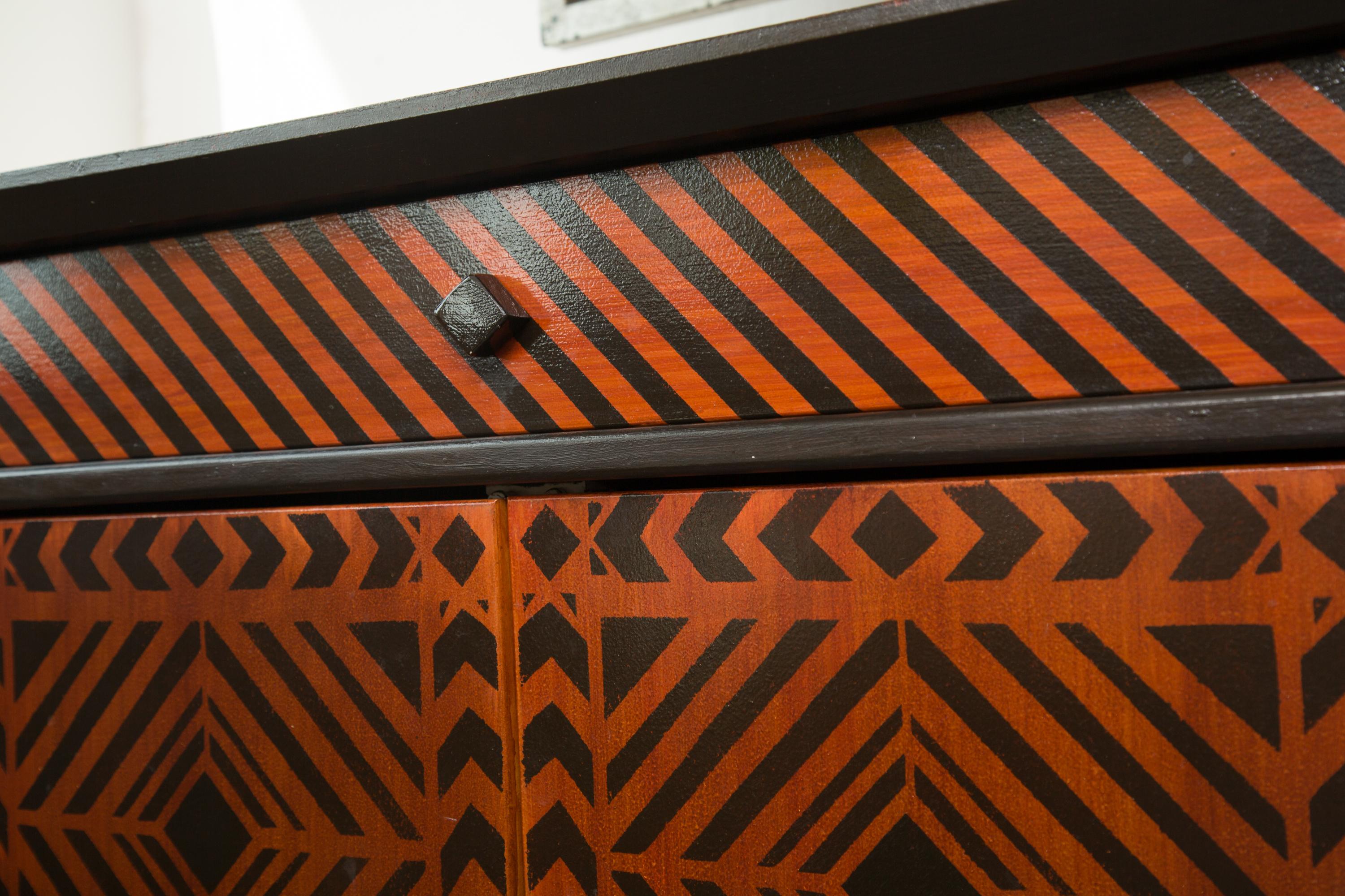 This stunning show-stopper is a custom designed credenza or sideboard., originally commissioned by fashion designer, Arnold Scassi for his residence. The entire cabinet is decorated overall in a brown and black geometric pattern, creating an op art