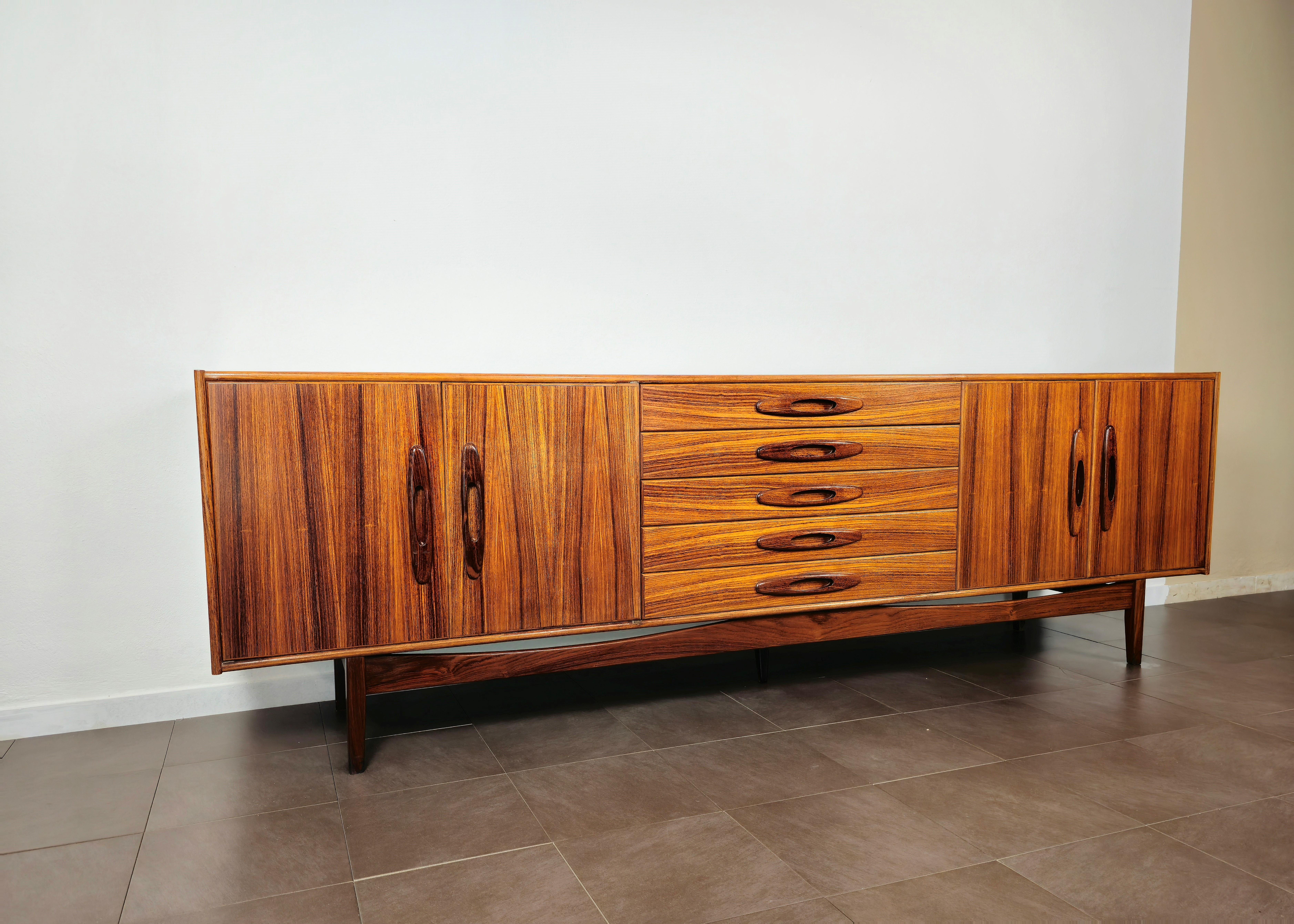 Elegant sideboard of considerable size attributable to the Danish designer ib kofod larsen and produced in the 60s.
The 5 foot sideboard was made in wood with 4 doors and 5 drawers.