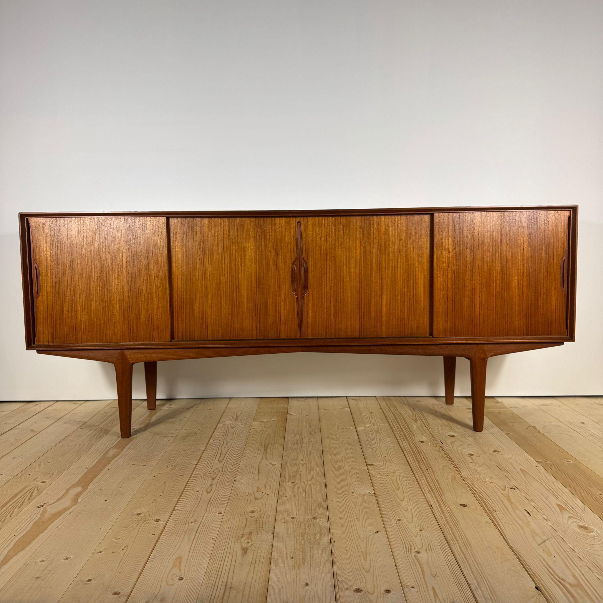 Questa credenza danese degli anni Sessanta è un perfetto esempio del design Mid-Century scandinavo: essenziale nelle linee, ricca nella materia. Realizzato in teak impiallacciato, esprime una tonalità calda e naturale che si integra armoniosamente
