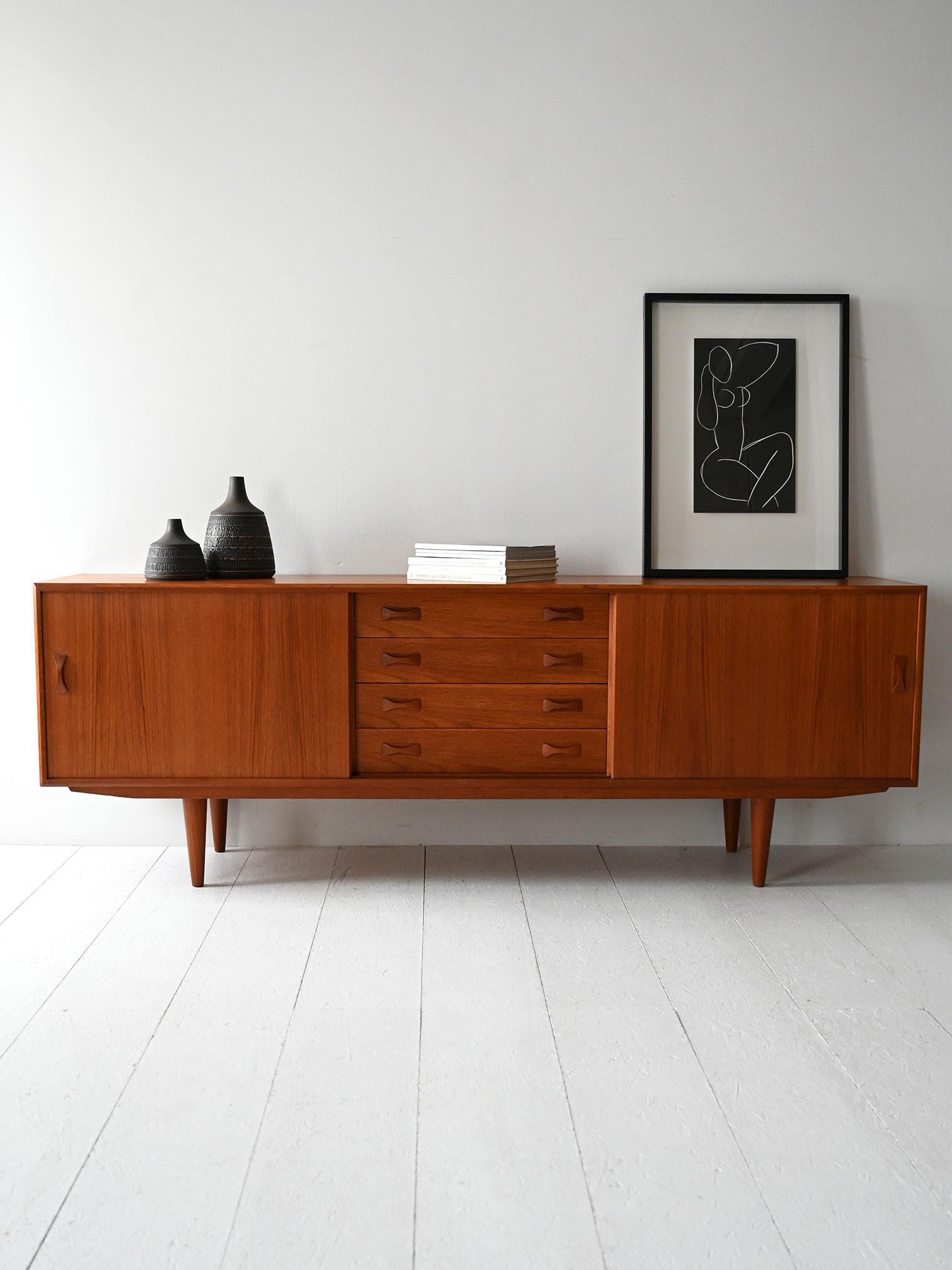 Credenza originale con etichetta, tre ante, cassetti centrali e maniglie scolpite applicate.

Sideboard danese originale anni '60, prodotto da Clausen & Søn a Silkeborg, con etichetta autentica ancora presente. Realizzato in teak con tre ante